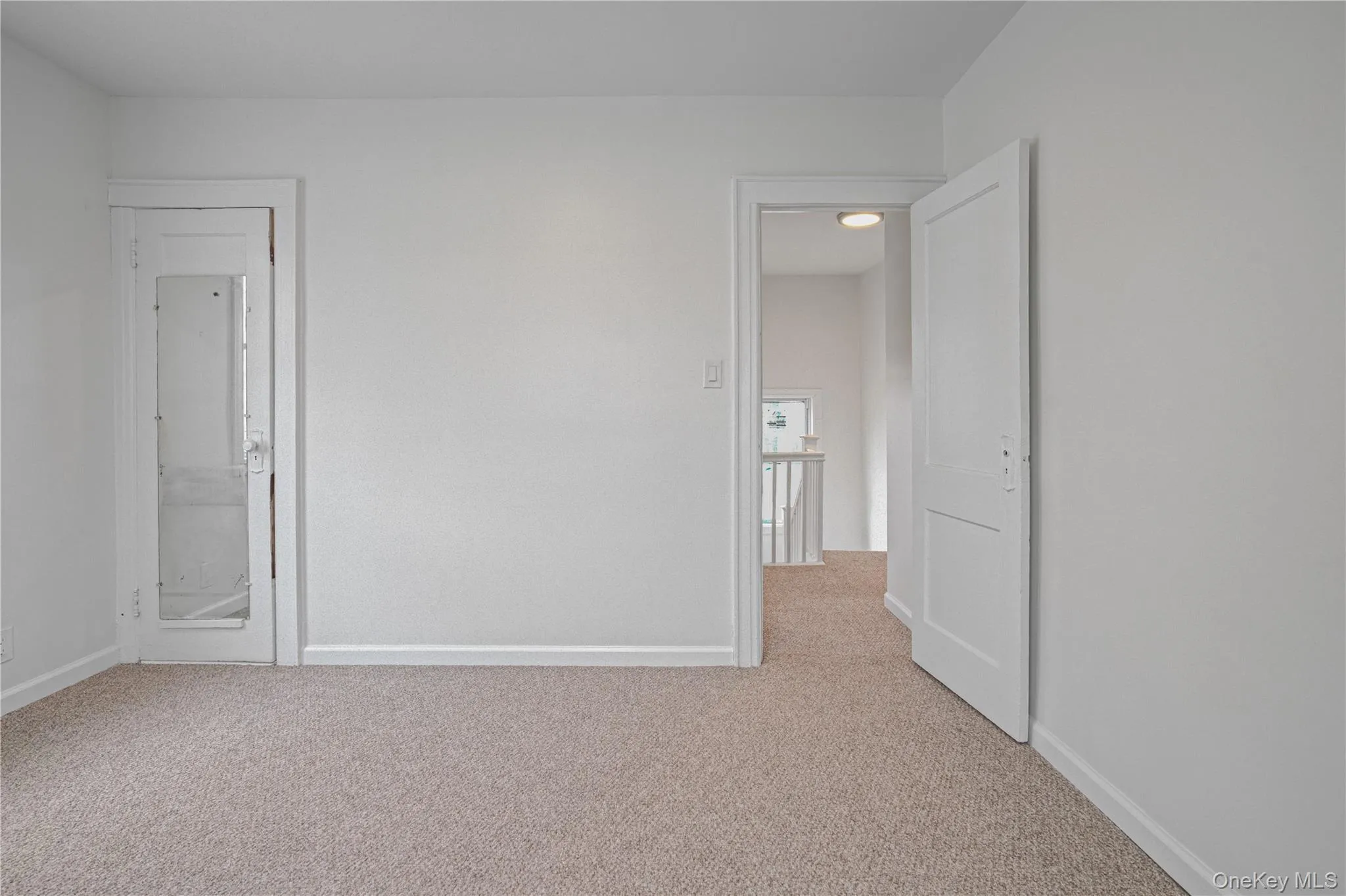 Unfurnished bedroom featuring light colored carpet and baseboards Unfurnished bedroom featuring light colored carpet and baseboards