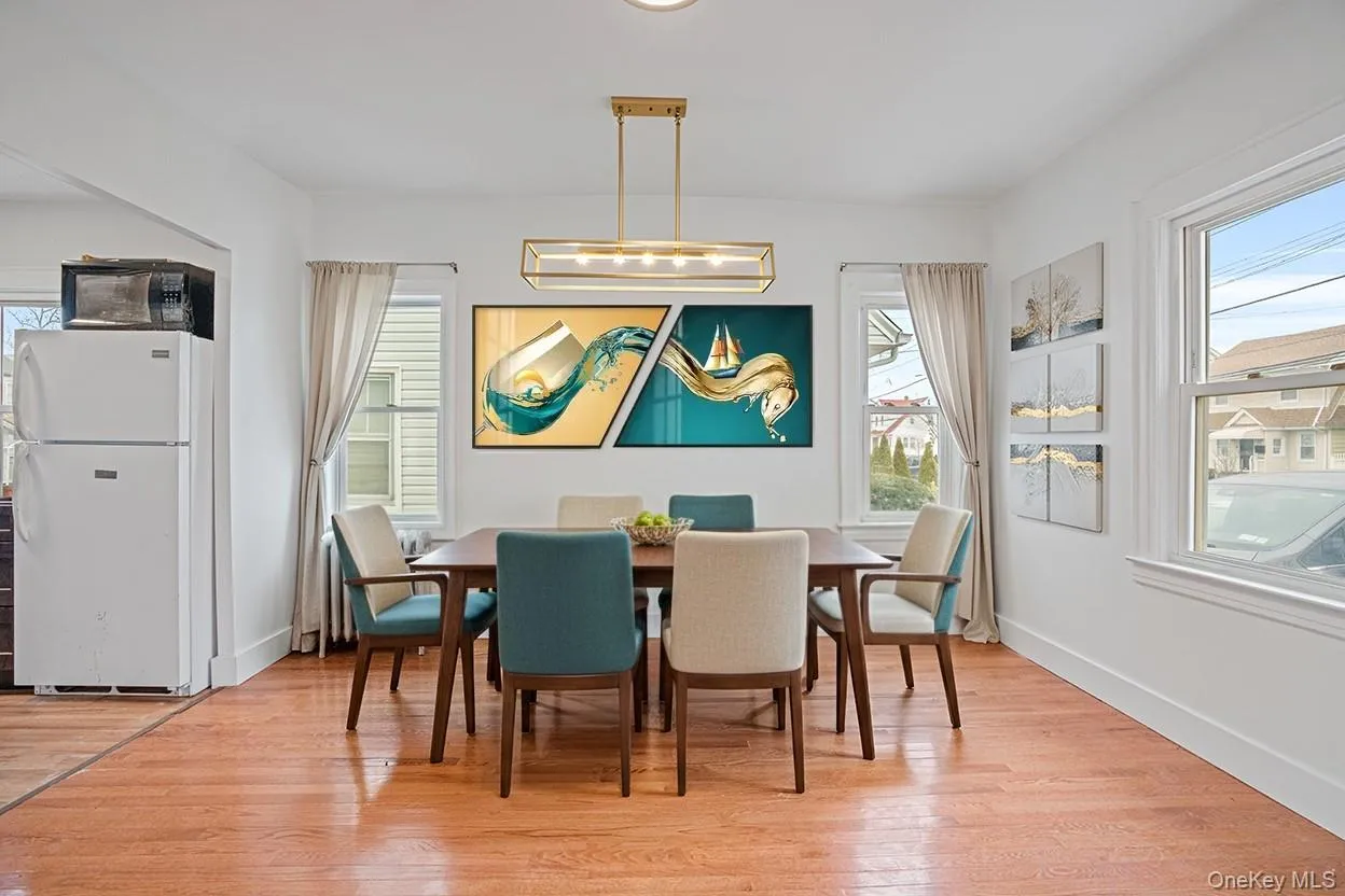 Dining space featuring plenty of natural light, light wood finished floors, and a chandelier Dining space featuring plenty of natural light, light wood finished floors, and a chandelier