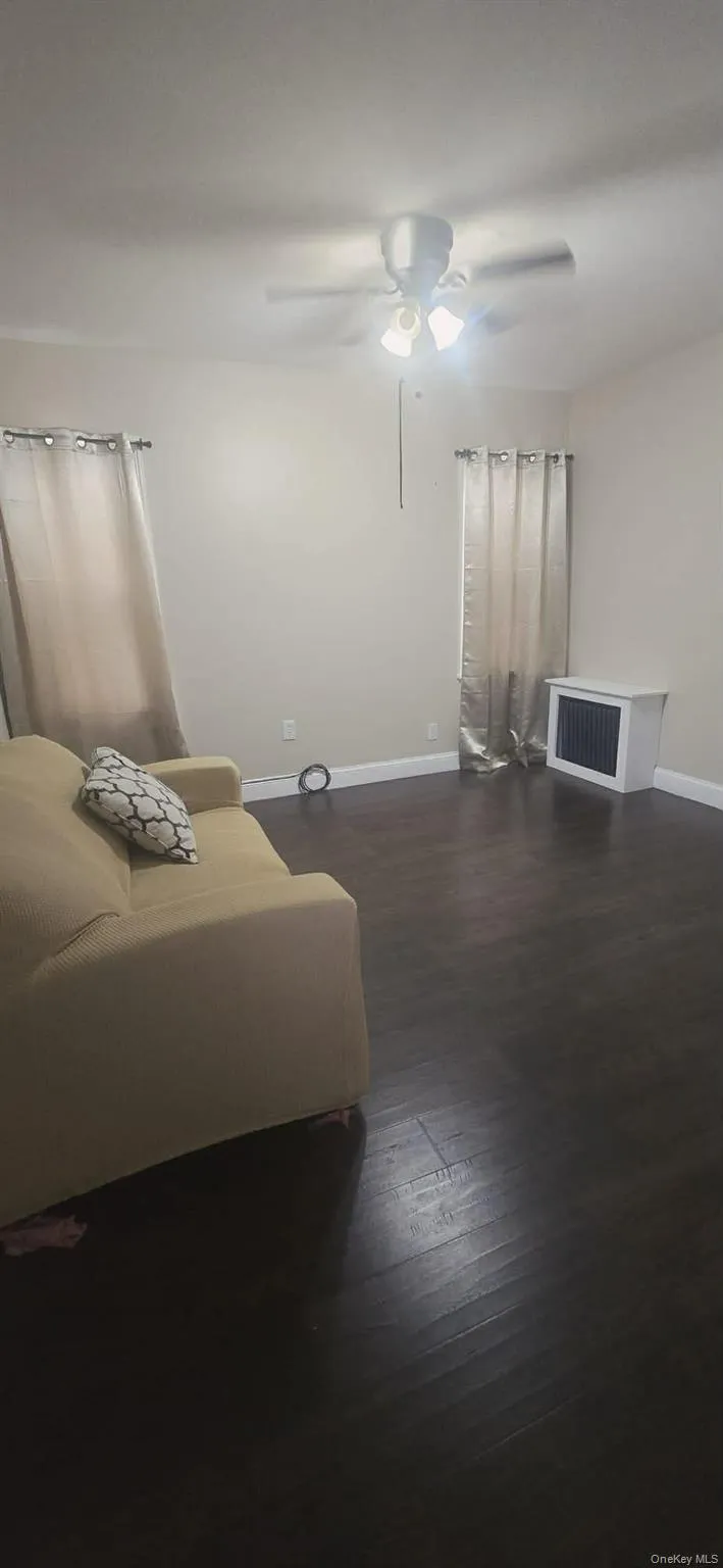 Bedroom with ceiling fan and dark wood-style floors Bedroom with ceiling fan and dark wood-style floors