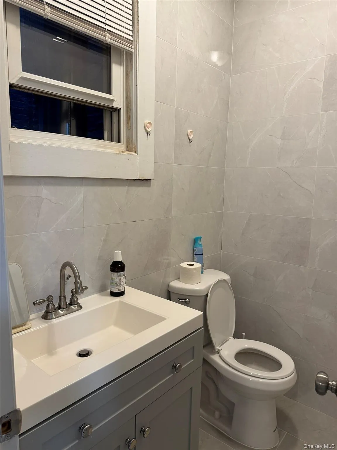 Bathroom featuring tile walls, backsplash, and vanity Bathroom featuring tile walls, backsplash, and vanity