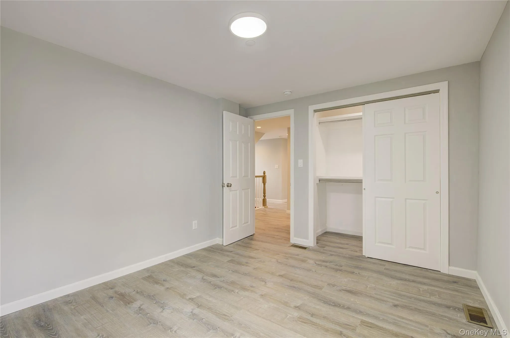 Unfurnished bedroom with light wood-type flooring and a closet Unfurnished bedroom with light wood-type flooring and a closet