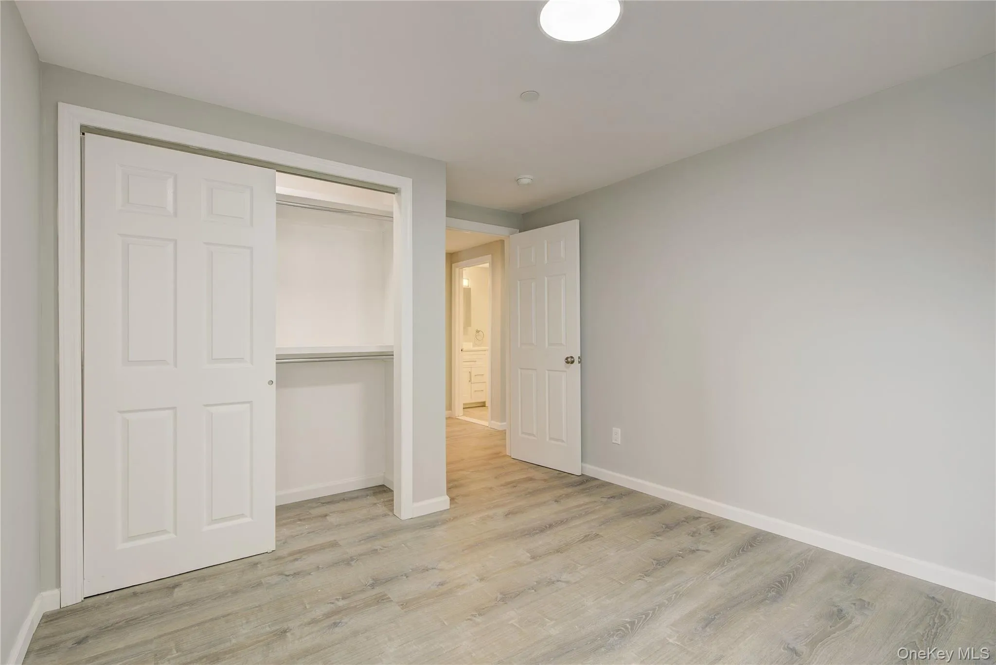 Unfurnished bedroom with wood finished floors and a closet Unfurnished bedroom with wood finished floors and a closet