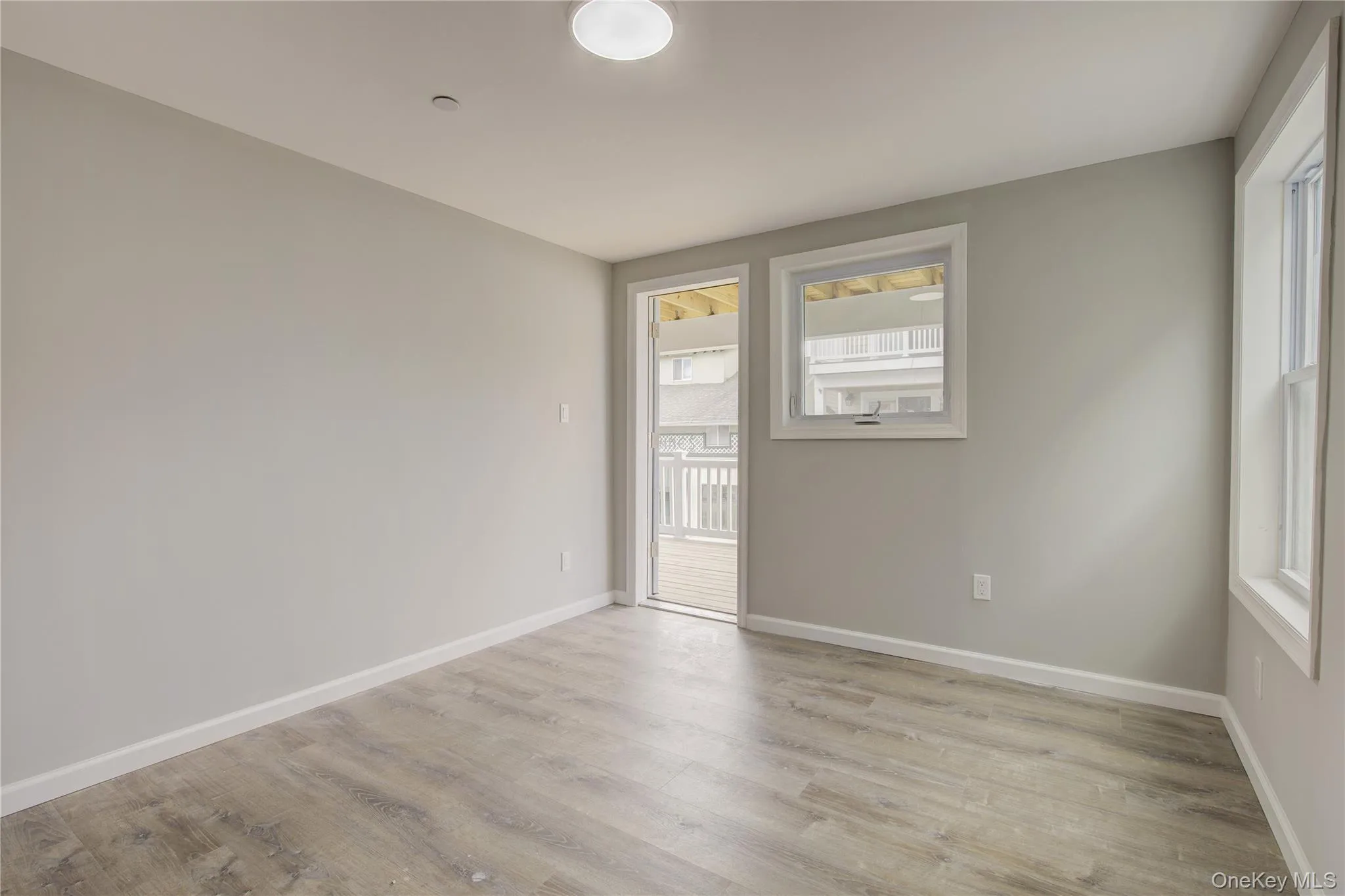 Empty room with light wood-type flooring and baseboards Empty room with light wood-type flooring and baseboards