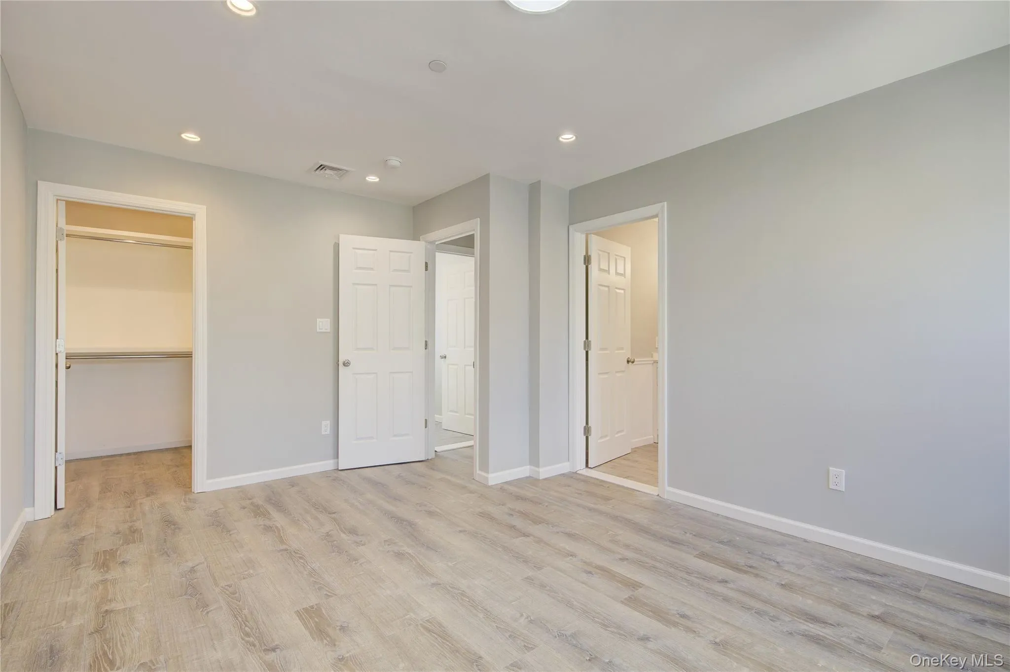 Unfurnished bedroom featuring a spacious closet, recessed lighting, light wood-type flooring, and a closet Unfurnished bedroom featuring a spacious closet, recessed lighting, light wood-type flooring, and a closet