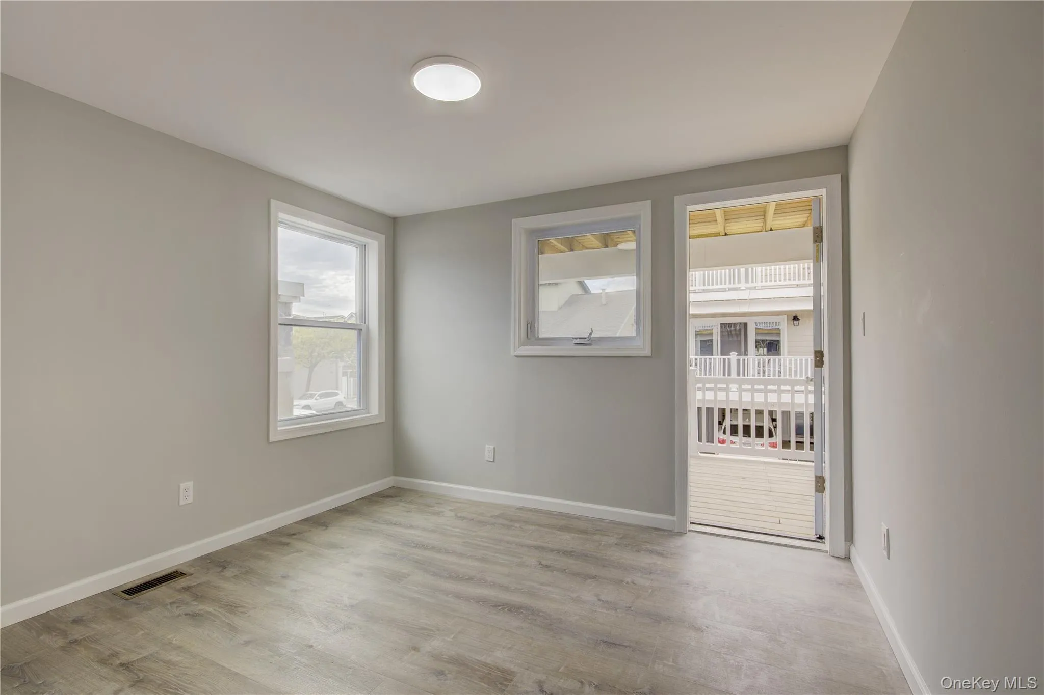 Unfurnished room with light wood-style floors and baseboards Unfurnished room with light wood-style floors and baseboards