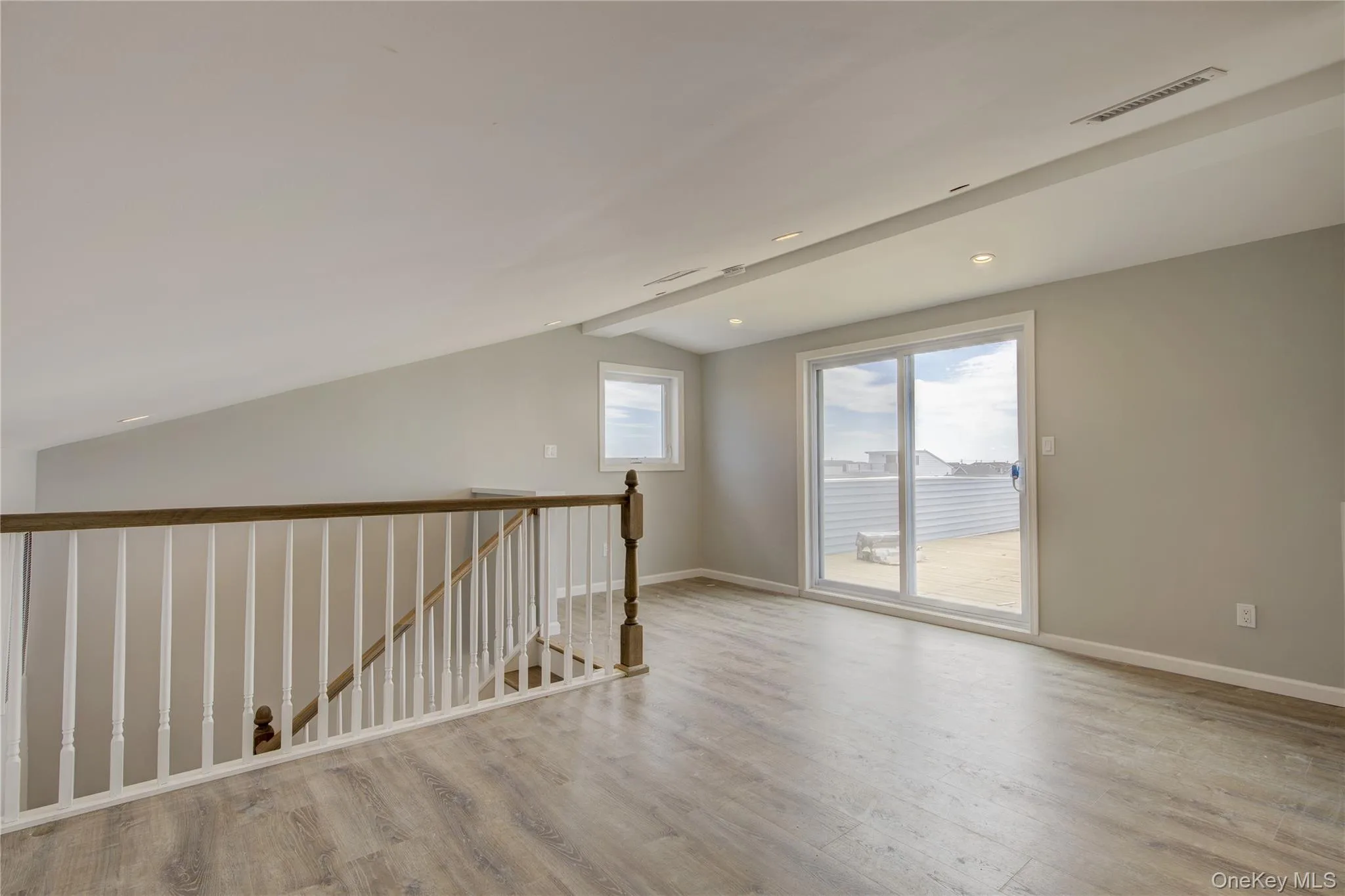 Spare room featuring vaulted ceiling and wood finished floors Spare room featuring vaulted ceiling and wood finished floors