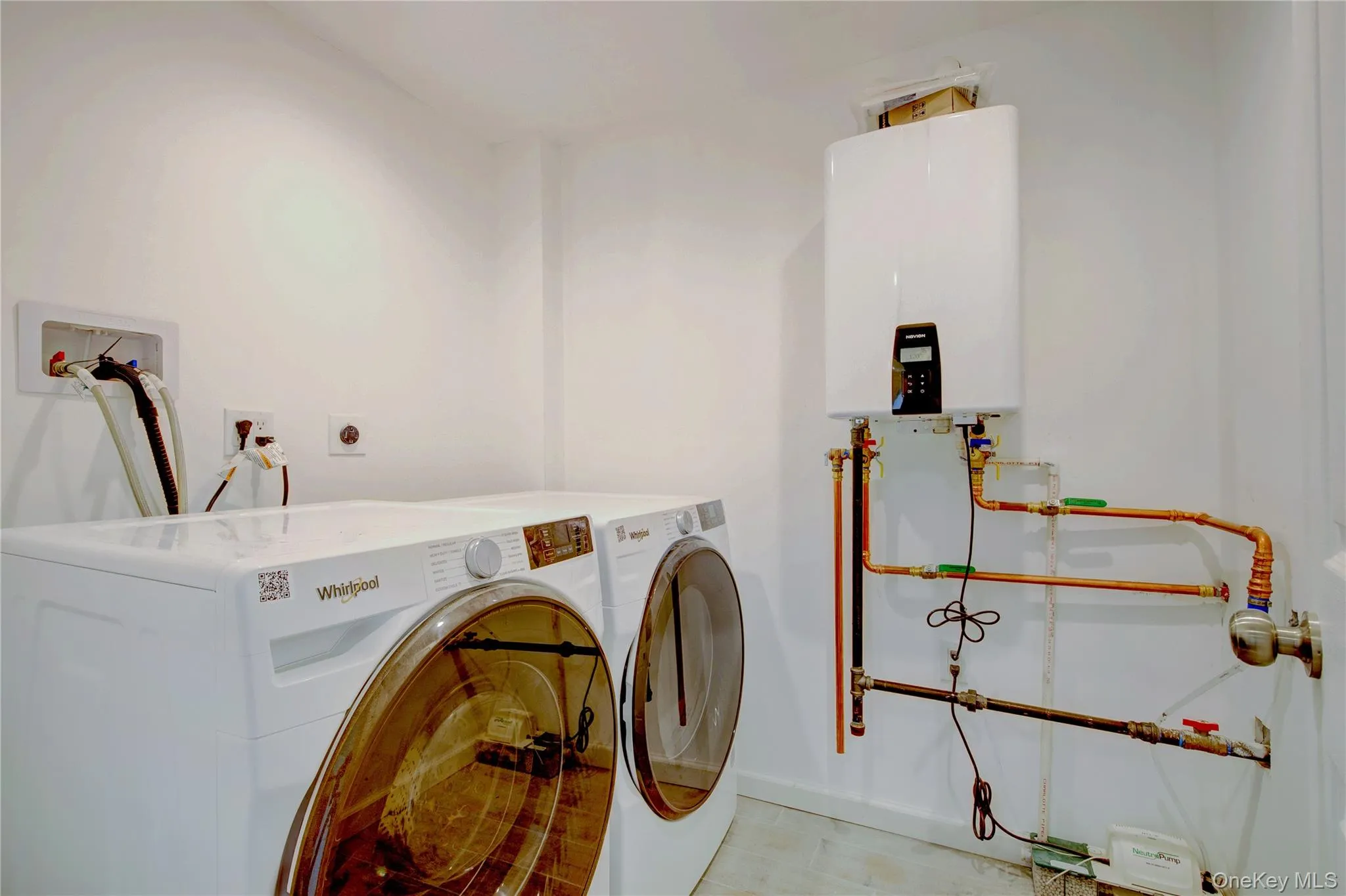 Laundry room with tankless water heater and separate washer and dryer Laundry room with tankless water heater and separate washer and dryer