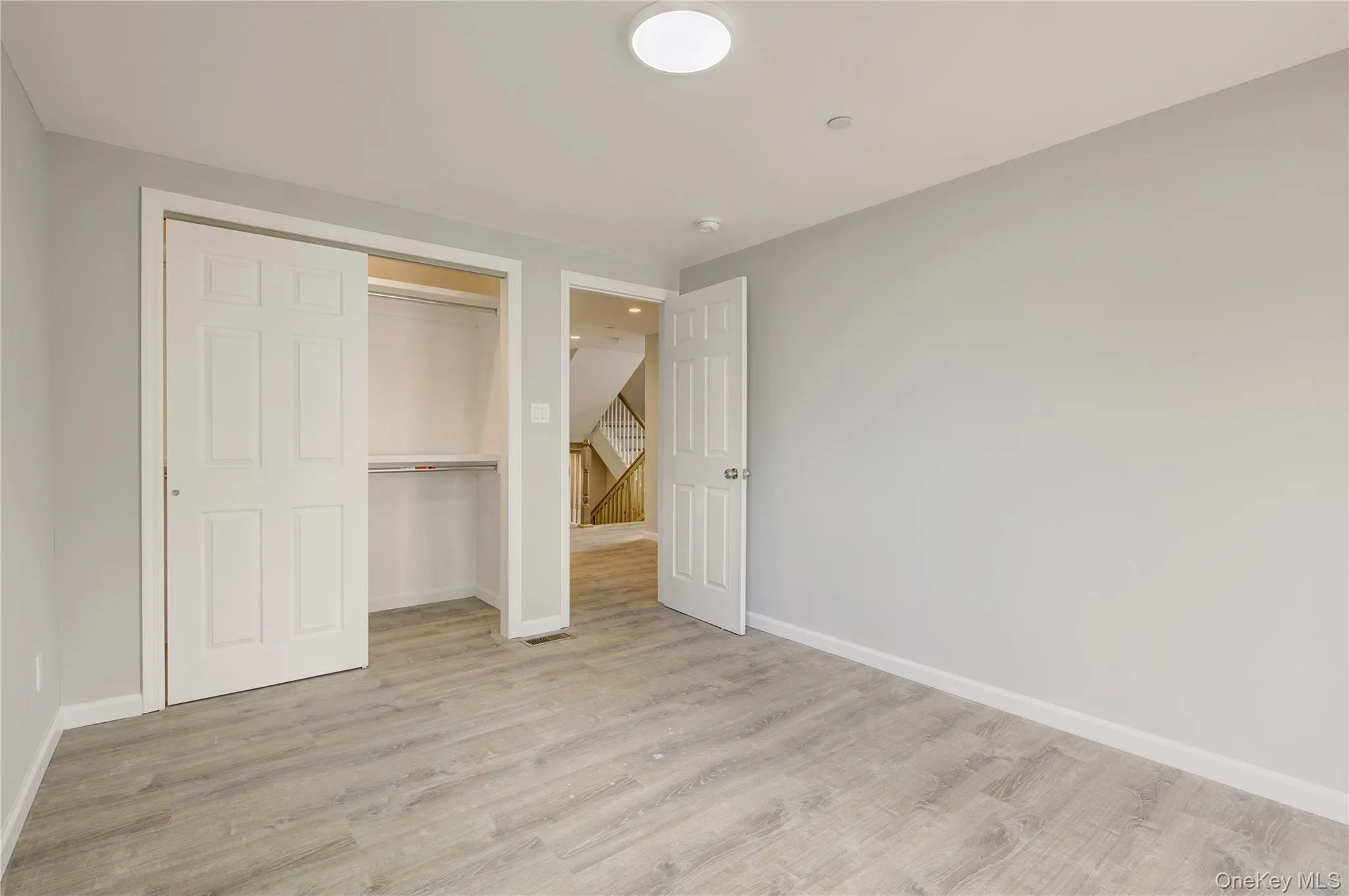 Unfurnished bedroom featuring light wood finished floors and a closet Unfurnished bedroom featuring light wood finished floors and a closet