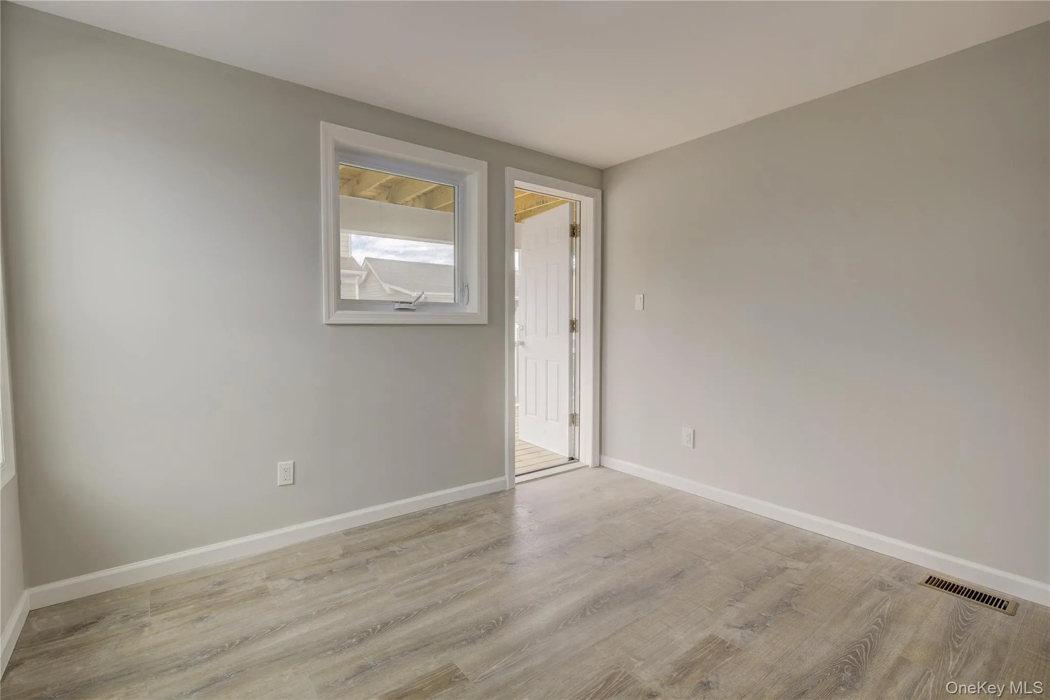 Spare room featuring wood finished floors and baseboards Spare room featuring wood finished floors and baseboards