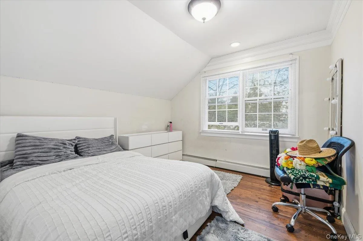 2nd floor Bedroom #2 featuring wood finished floors, a baseboard heating unit, vaulted ceiling, recessed lighting, and crown molding 2nd floor Bedroom #2 featuring wood finished floors, a baseboard heating unit, vaulted ceiling, recessed lighting, and crown molding