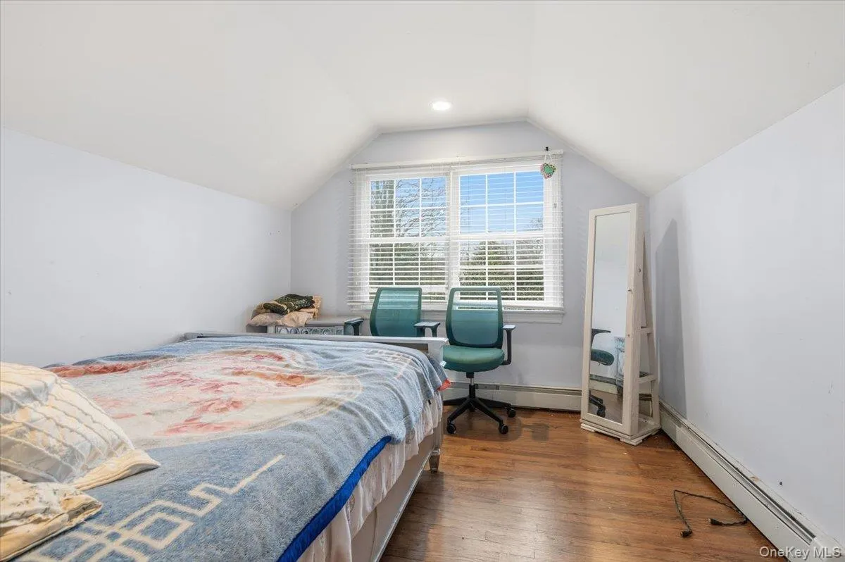 2nd floor Bedroom #3 with sitting area/nursery, featuring wood-type flooring, lofted ceiling, and baseboard heating 2nd floor Bedroom #3 with sitting area/nursery, featuring wood-type flooring, lofted ceiling, and baseboard heating