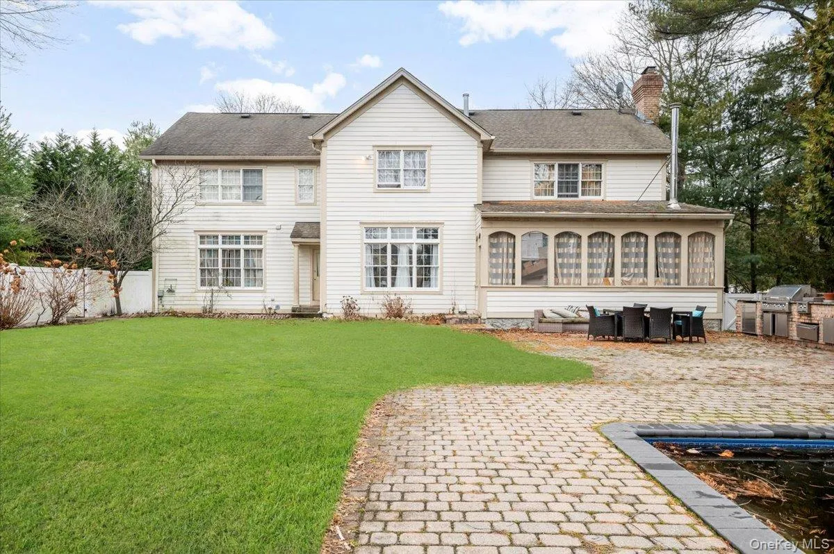 Back of property featuring a sunroom, a chimney, a patio, a shingled roof, and an outdoor living space Back of property featuring a sunroom, a chimney, a patio, a shingled roof, and an outdoor living space