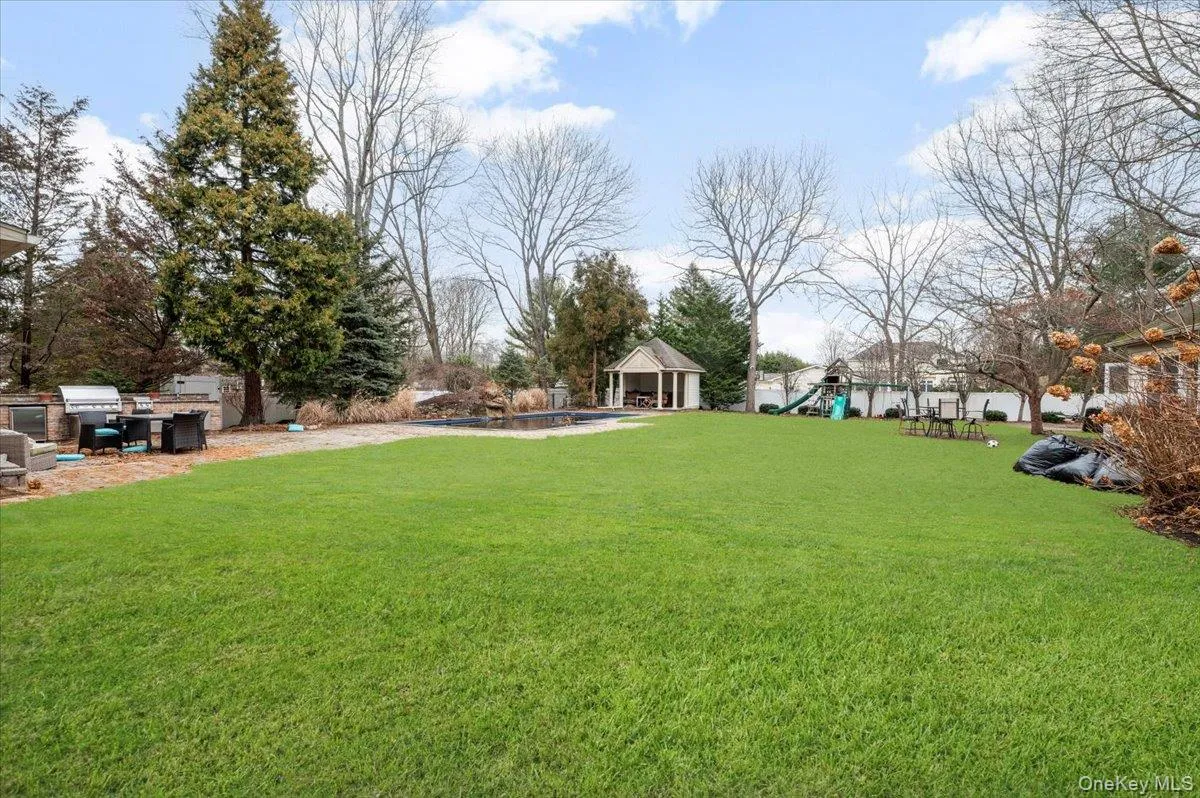 View of grassy yard featuring a playground, a patio area, and a swimming pool View of grassy yard featuring a playground, a patio area, and a swimming pool