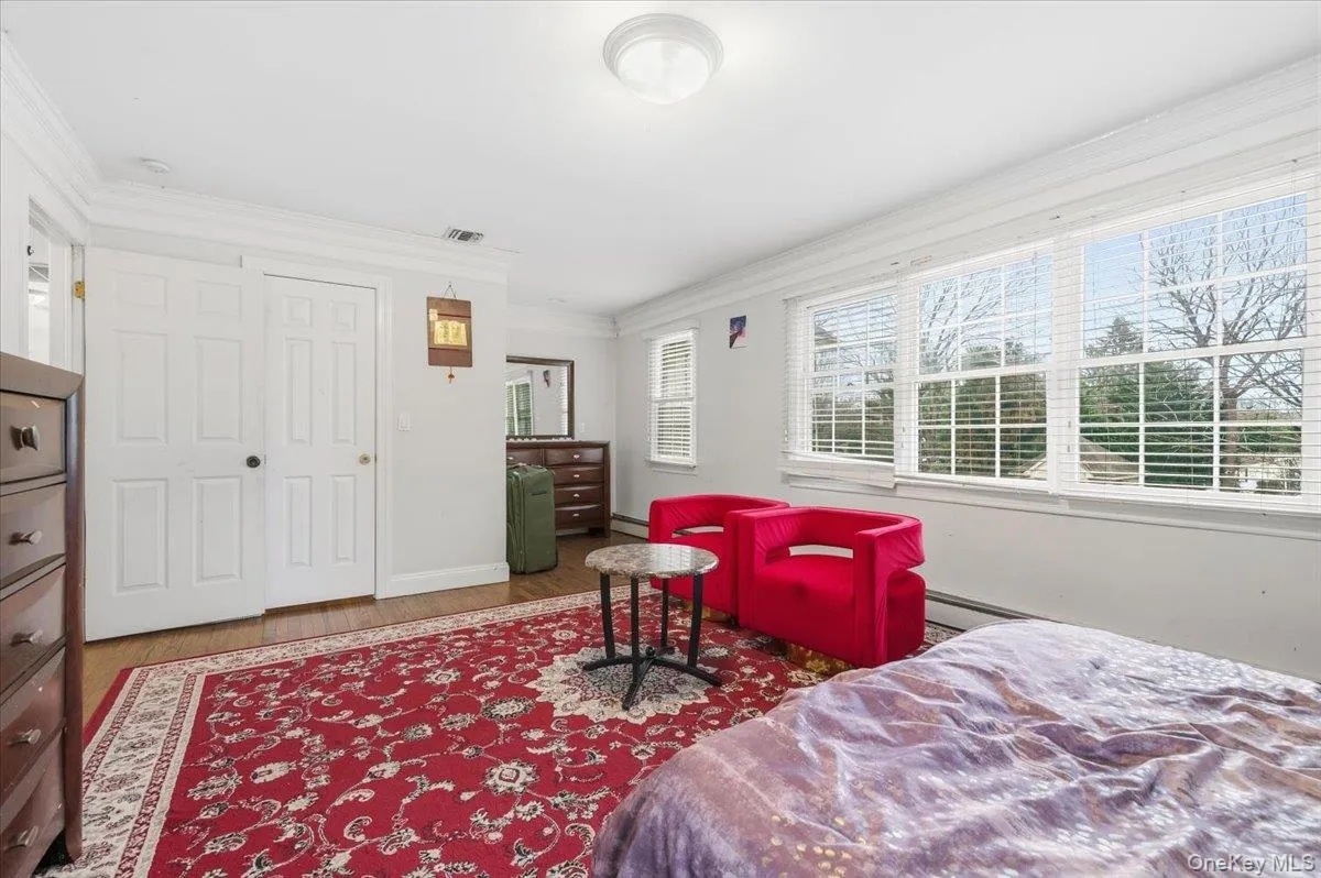 2nd floor Bedroom #6 with wood finished floors, ornamental molding, and a baseboard radiator 2nd floor Bedroom #6 with wood finished floors, ornamental molding, and a baseboard radiator