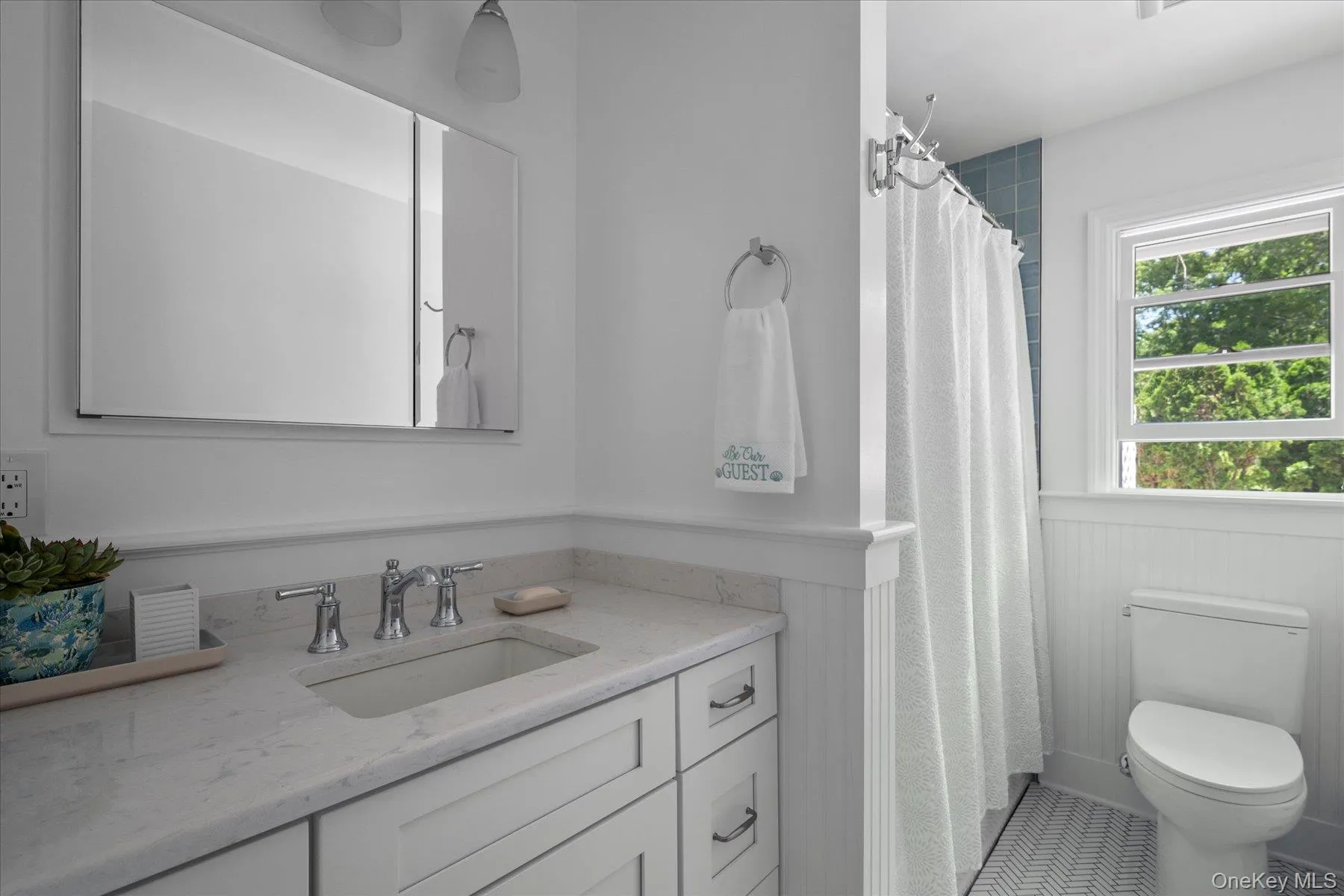 Full bathroom featuring a shower with curtain, vanity, and wainscoting Full bathroom featuring a shower with curtain, vanity, and wainscoting