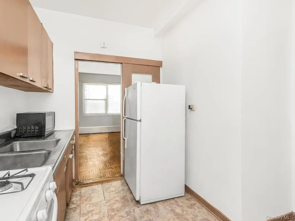Kitchen with white appliances, brown cabinets, and light countertops Kitchen with white appliances, brown cabinets, and light countertops