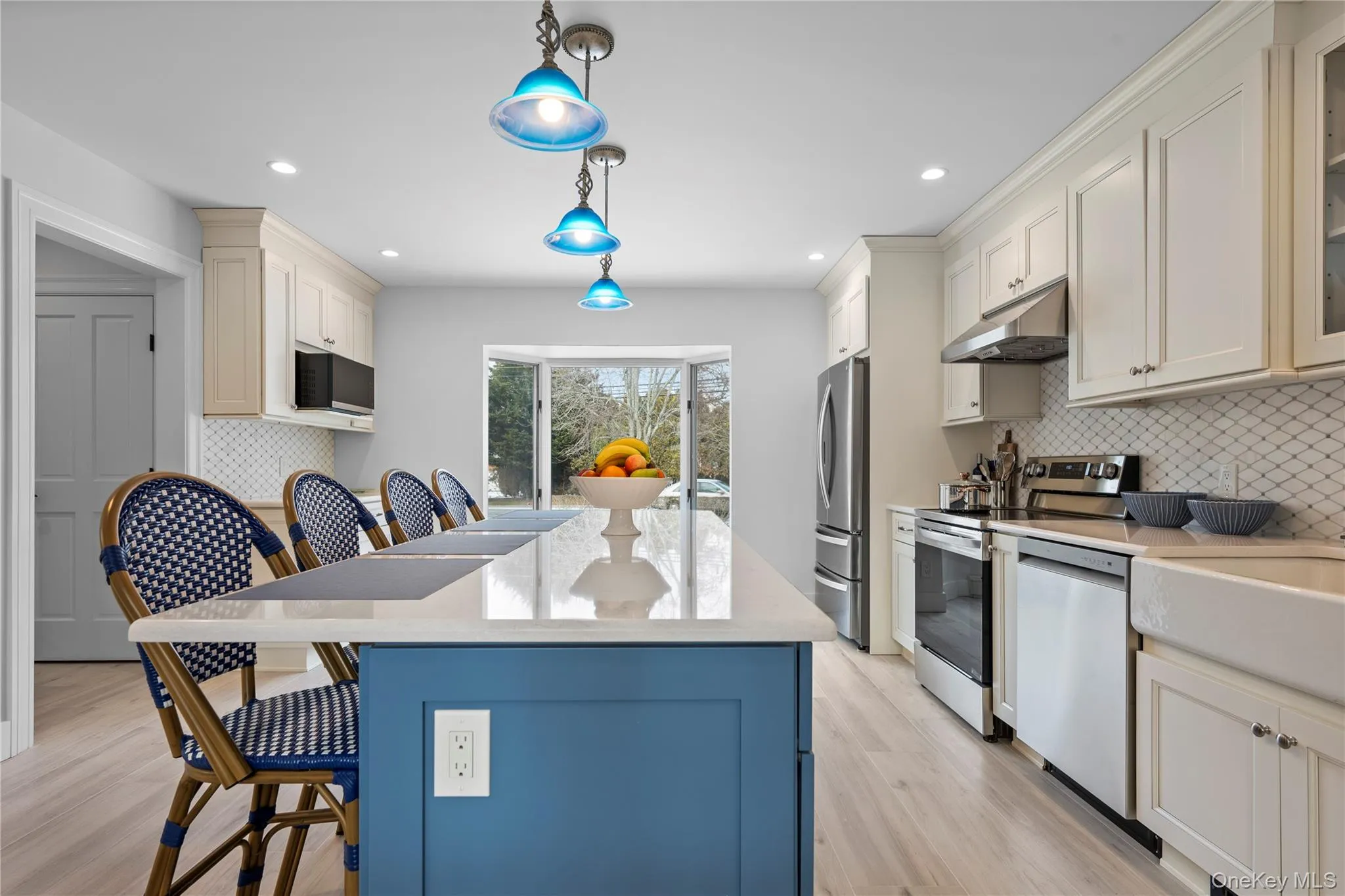 Kitchen with a breakfast bar area, decorative backsplash, appliances with stainless steel finishes, pendant lighting, and recessed lighting Kitchen with a breakfast bar area, decorative backsplash, appliances with stainless steel finishes, pendant lighting, and recessed lighting