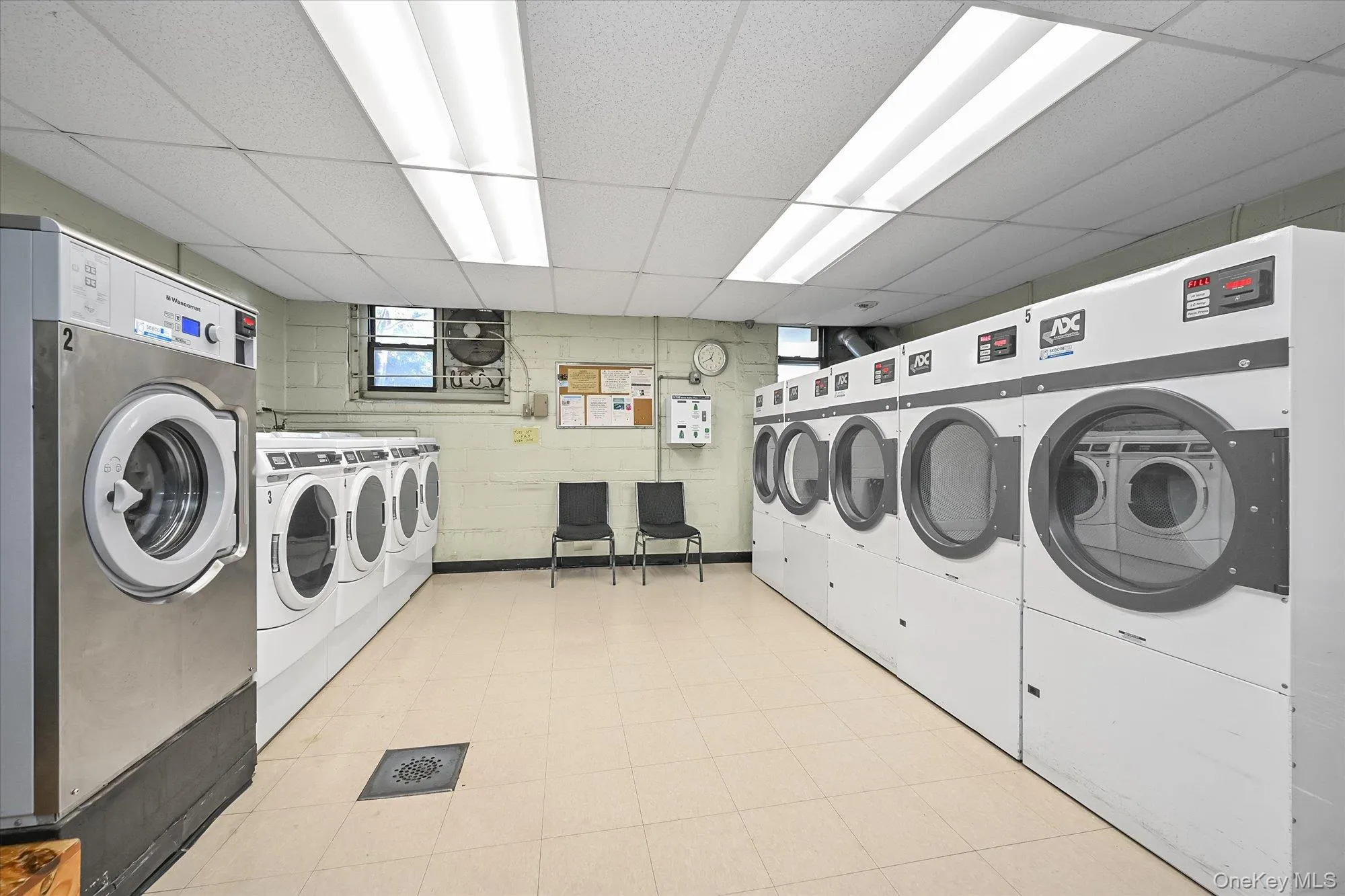 Shared laundry room featuring a drop ceiling and washing machine and dryer Shared laundry room featuring a drop ceiling and washing machine and dryer