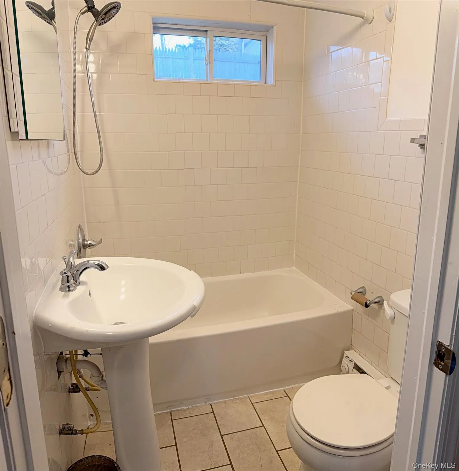 Full bath featuring bathtub / shower combination, light tile patterned floors, and a baseboard radiator Full bath featuring bathtub / shower combination, light tile patterned floors, and a baseboard radiator