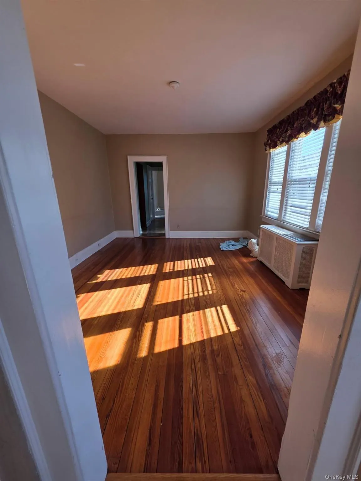 Spare room with radiator and hardwood / wood-style flooring Spare room with radiator and hardwood / wood-style flooring