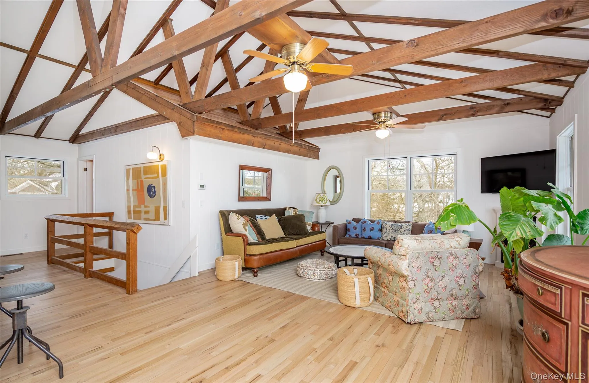 Living room featuring light wood finished floors, high vaulted ceiling, beam ceiling, and a ceiling fan Living room featuring light wood finished floors, high vaulted ceiling, beam ceiling, and a ceiling fan