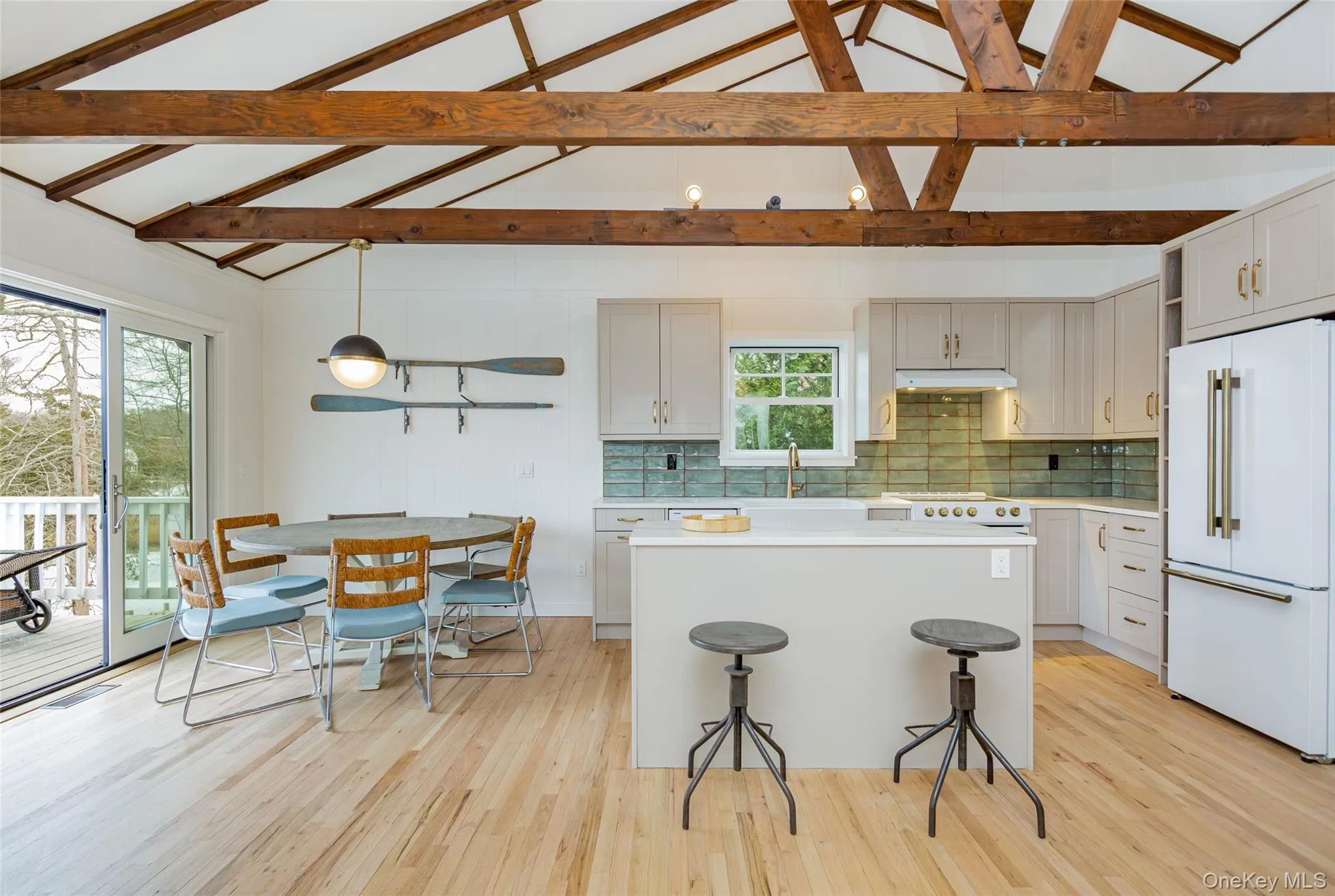 Kitchen with high end fridge, decorative backsplash, light wood-style floors, a center island, and decorative light fixtures Kitchen with high end fridge, decorative backsplash, light wood-style floors, a center island, and decorative light fixtures