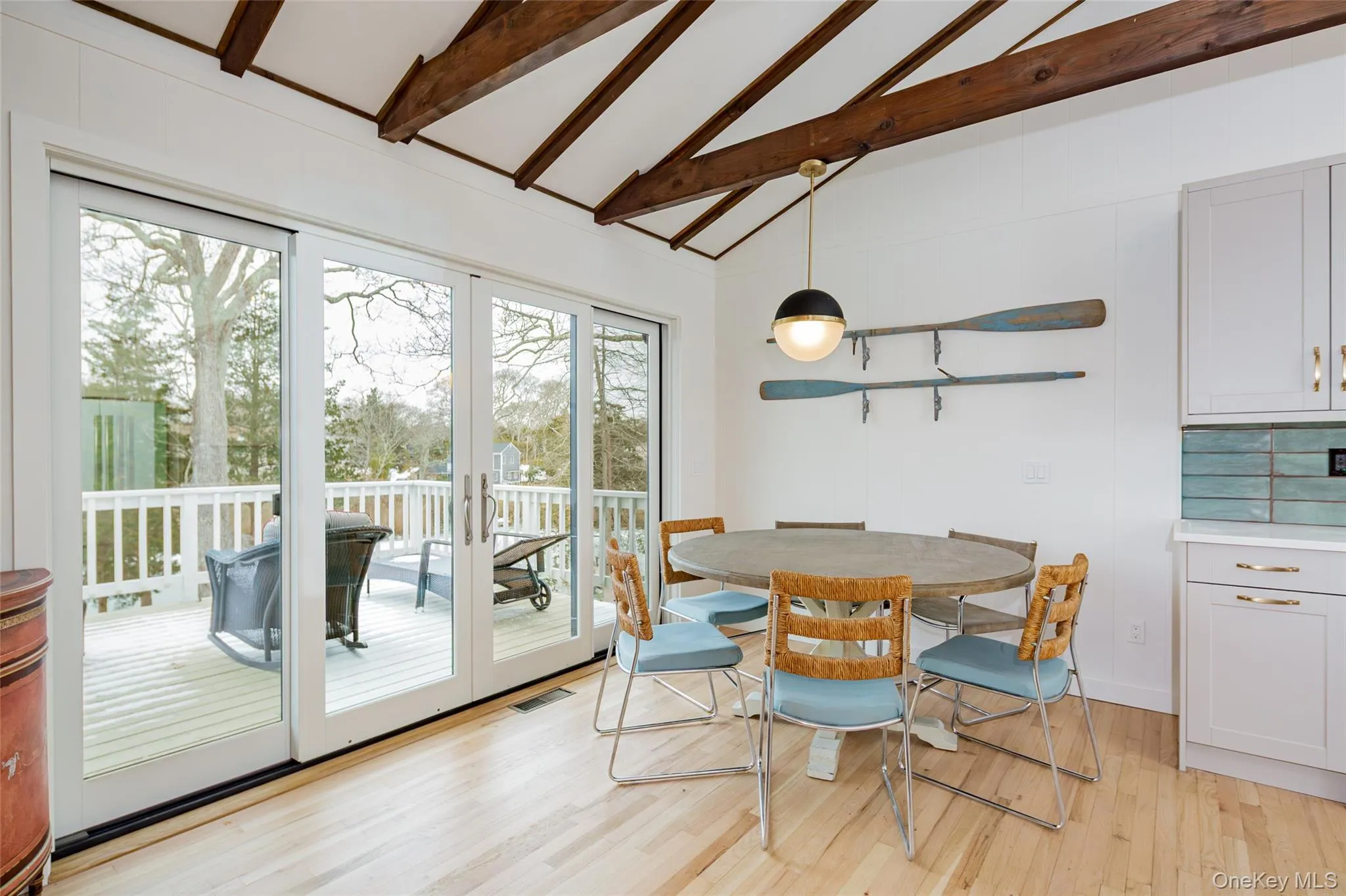 Dining area featuring beam ceiling, light wood-style floors, french doors, and high vaulted ceiling Dining area featuring beam ceiling, light wood-style floors, french doors, and high vaulted ceiling