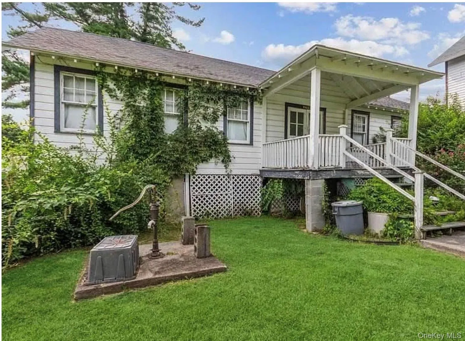 Back of house with a yard, covered porch, and stairway Back of house with a yard, covered porch, and stairway