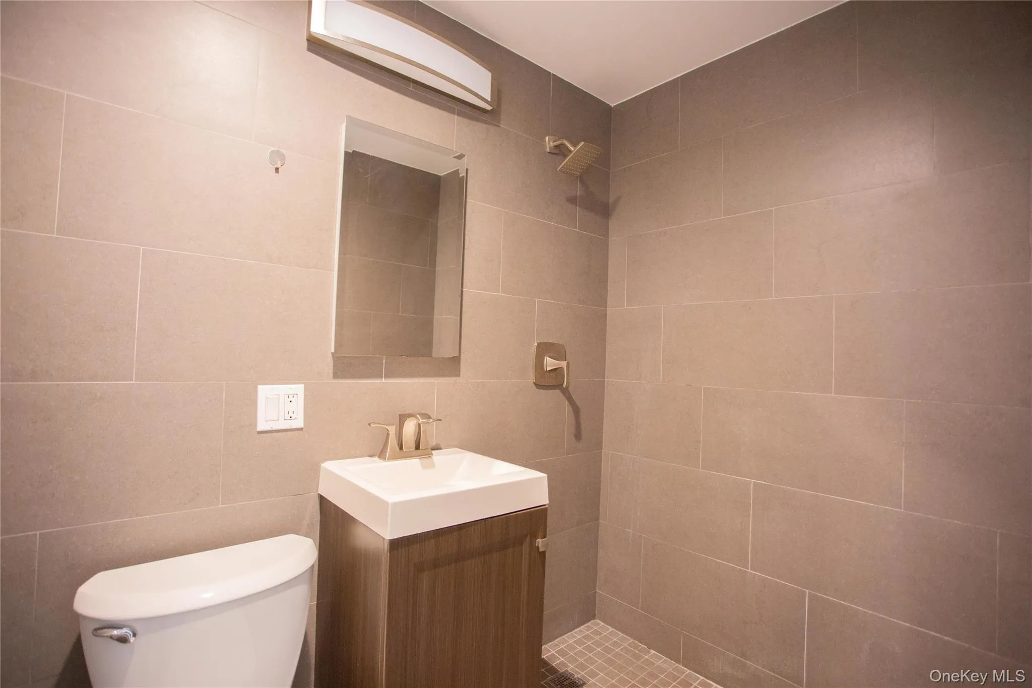 Full bathroom featuring vanity, tile walls, and a shower stall Full bathroom featuring vanity, tile walls, and a shower stall