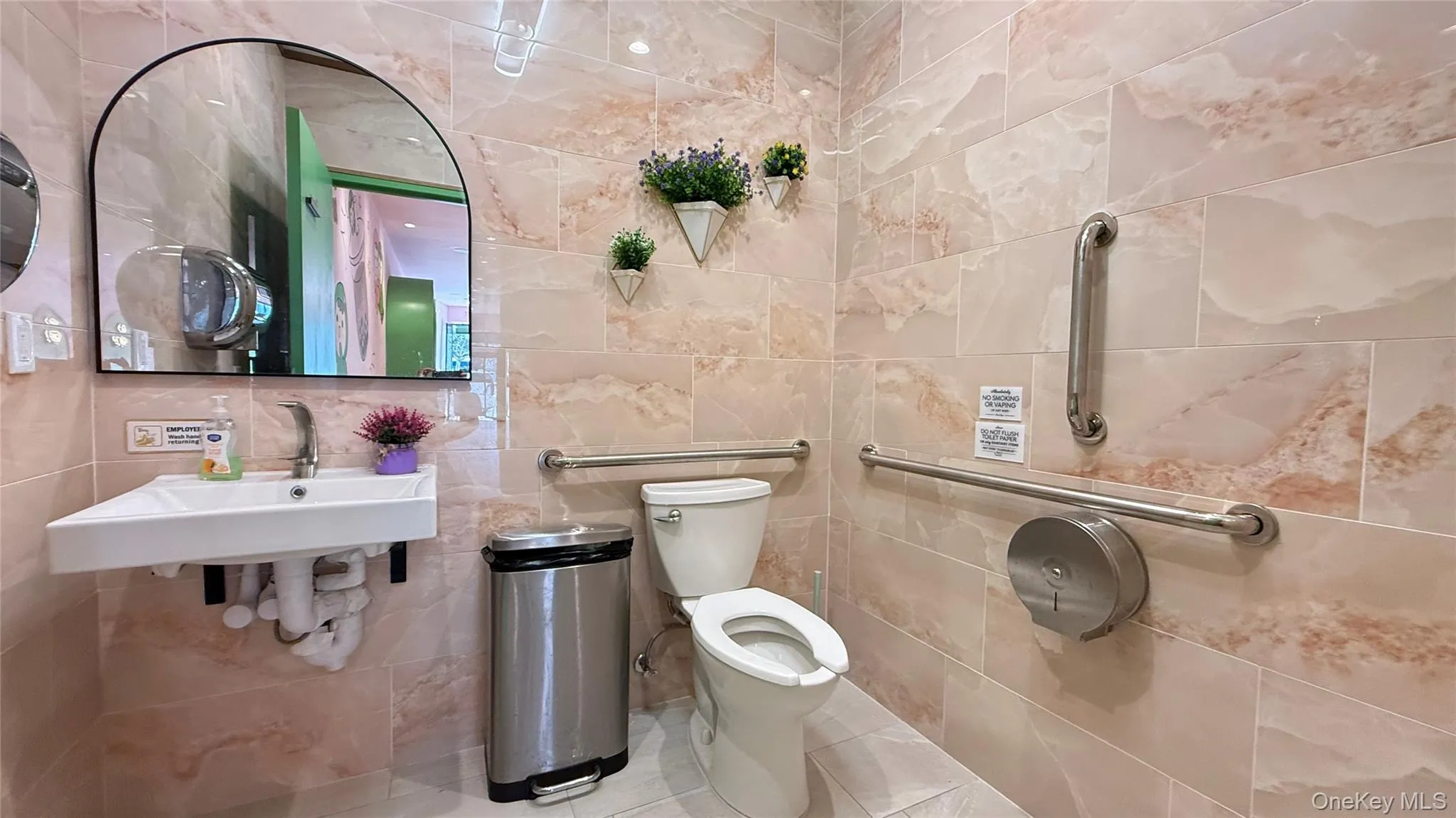 Half bathroom featuring a sink, tile walls, toilet, and tile patterned floors Half bathroom featuring a sink, tile walls, toilet, and tile patterned floors