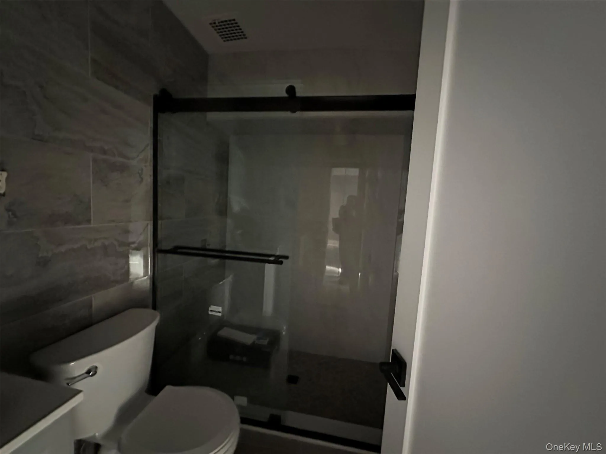 Full bath featuring tile walls, a stall shower, and vanity Full bath featuring tile walls, a stall shower, and vanity
