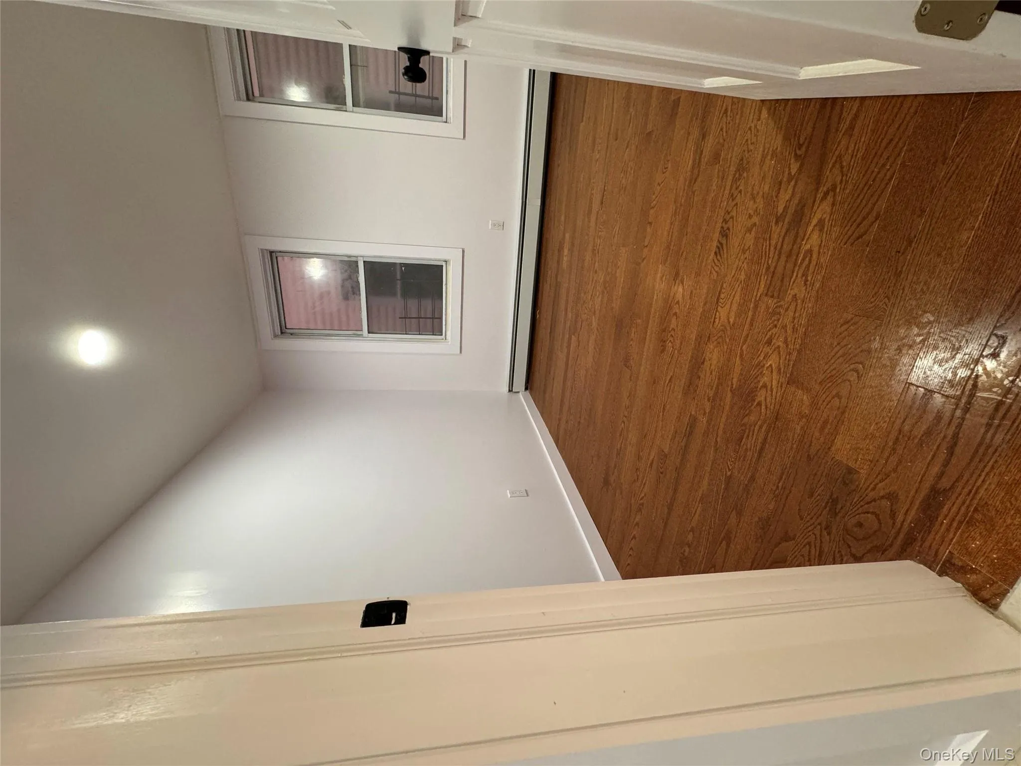 Spare room with dark wood-style flooring and baseboard heating Spare room with dark wood-style flooring and baseboard heating