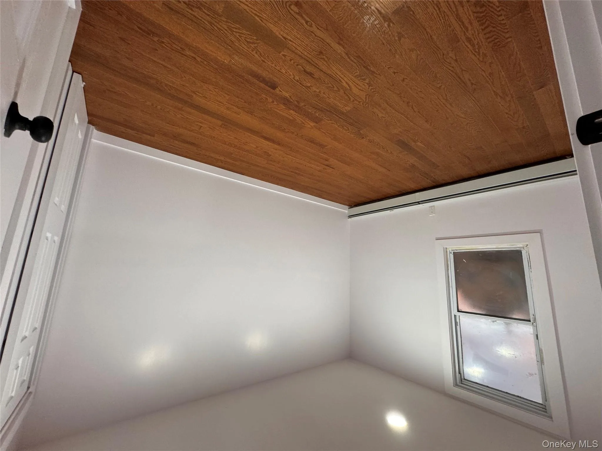 Unfurnished room with a baseboard heating unit, dark wood finished floors, and recessed lighting Unfurnished room with a baseboard heating unit, dark wood finished floors, and recessed lighting