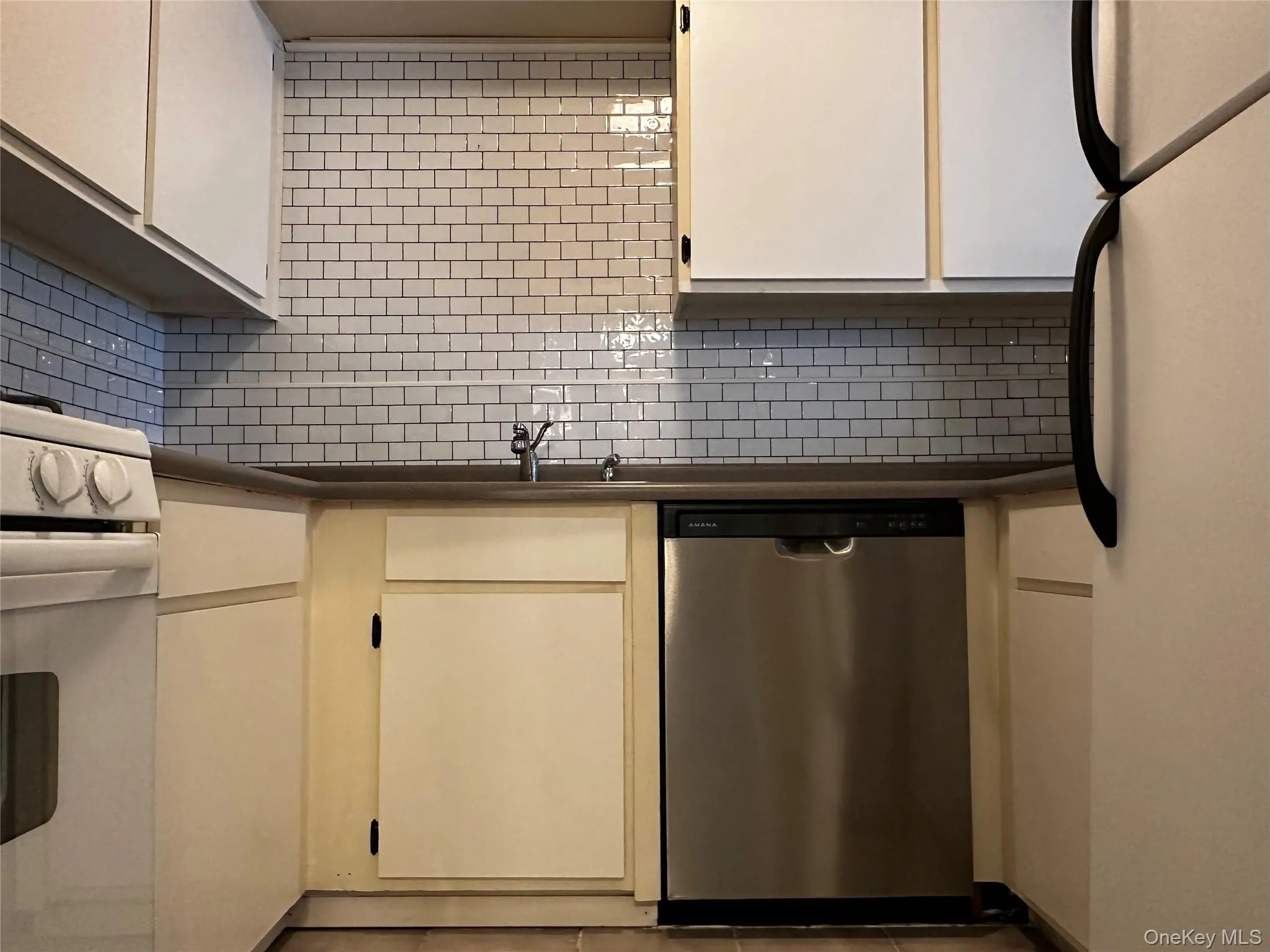 Kitchen featuring white appliances and tile backsplash Kitchen featuring white appliances and tile backsplash
