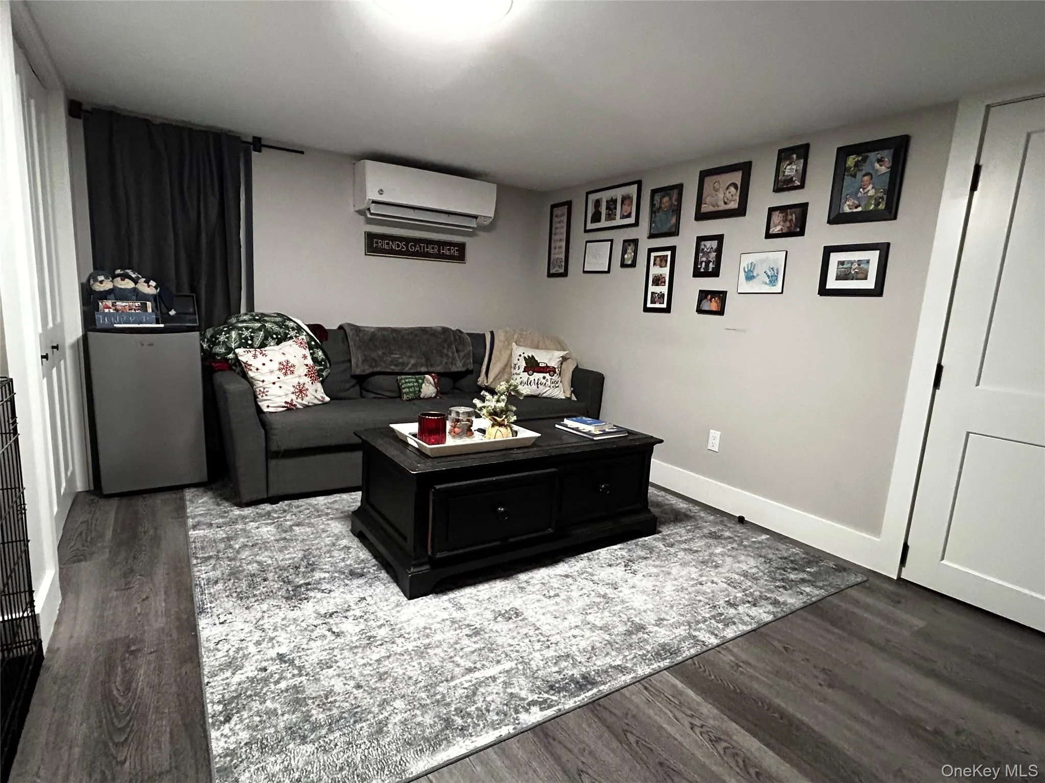Living area with dark wood finished floors and a wall unit AC Living area with dark wood finished floors and a wall unit AC