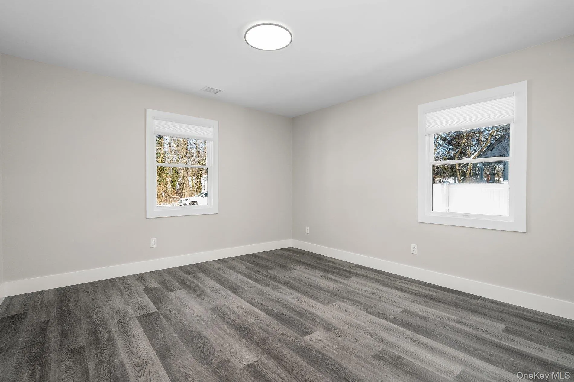 Spare room featuring wood finished floors and baseboards Spare room featuring wood finished floors and baseboards