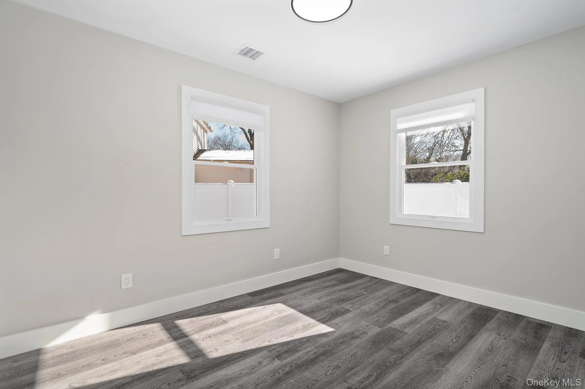 Unfurnished room featuring baseboards and dark wood finished floors Unfurnished room featuring baseboards and dark wood finished floors