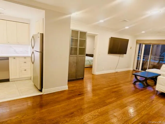 Living room featuring light wood-style flooring, recessed lighting, and crown molding Living room featuring light wood-style flooring, recessed lighting, and crown molding