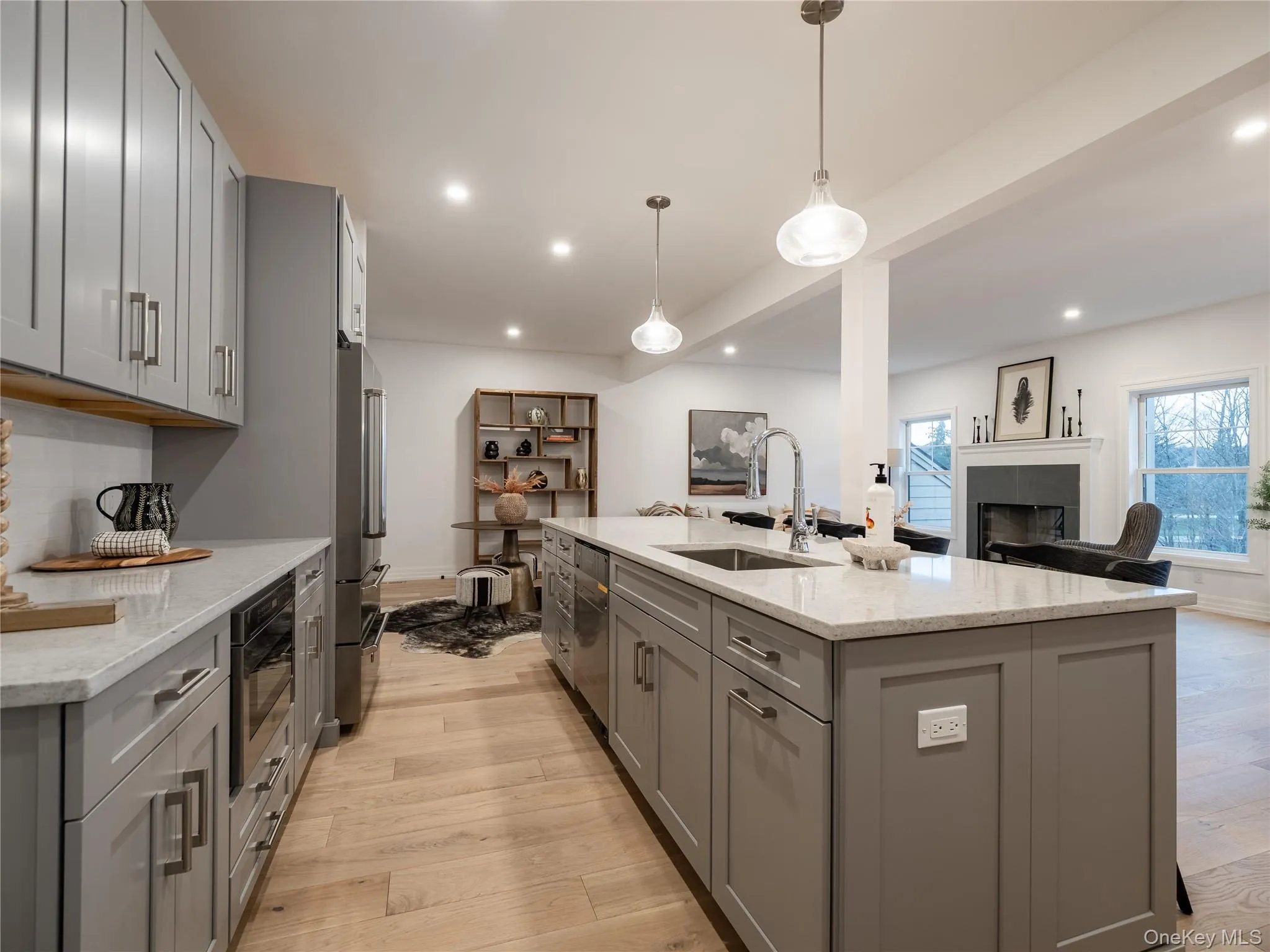 Kitchen featuring gray cabinets, light wood-style flooring, light stone counters, and recessed lighting Kitchen featuring gray cabinets, light wood-style flooring, light stone counters, and recessed lighting