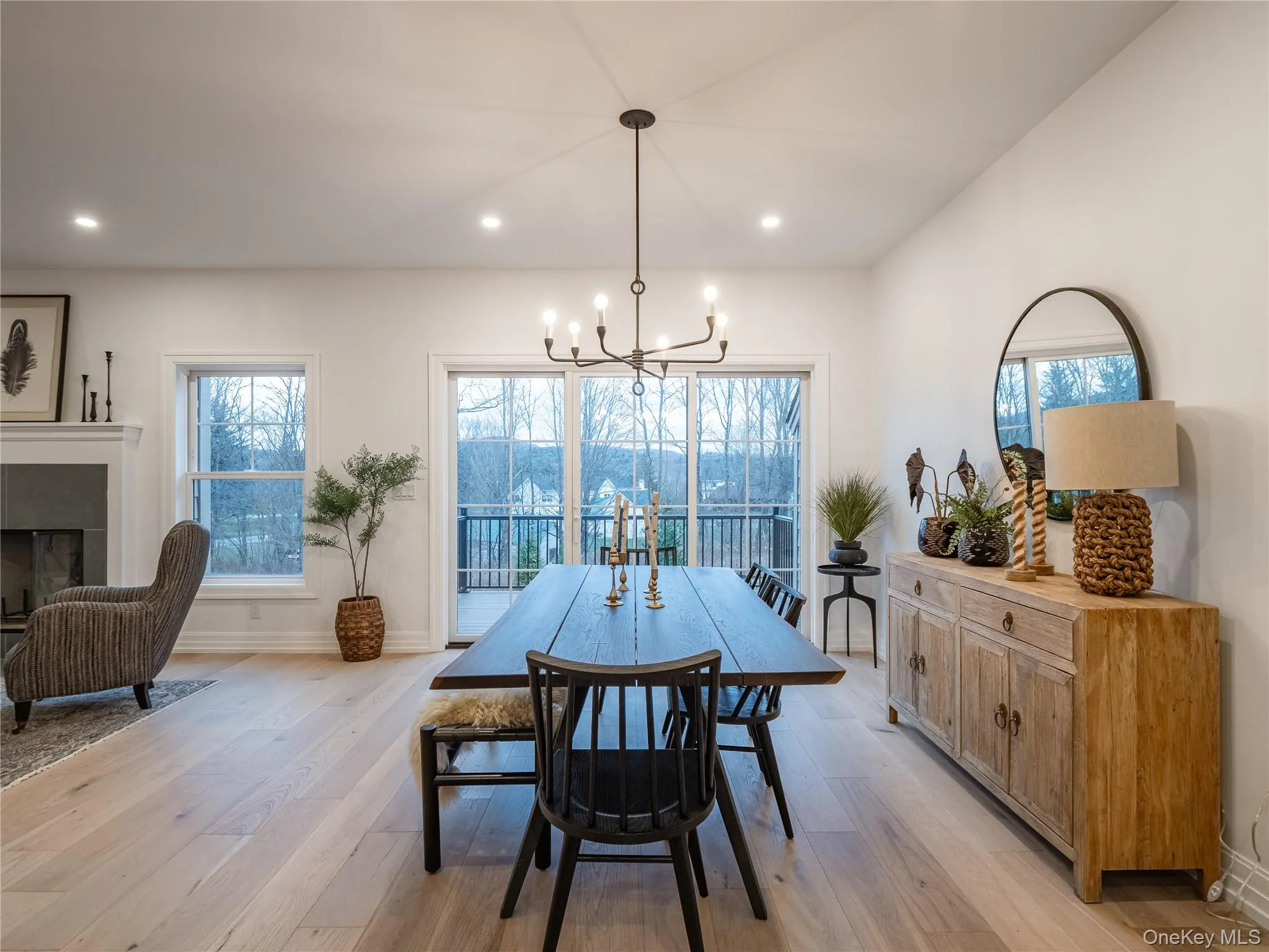 Dining area with light wood-style floors, recessed lighting, a tiled fireplace, and a chandelier Dining area with light wood-style floors, recessed lighting, a tiled fireplace, and a chandelier