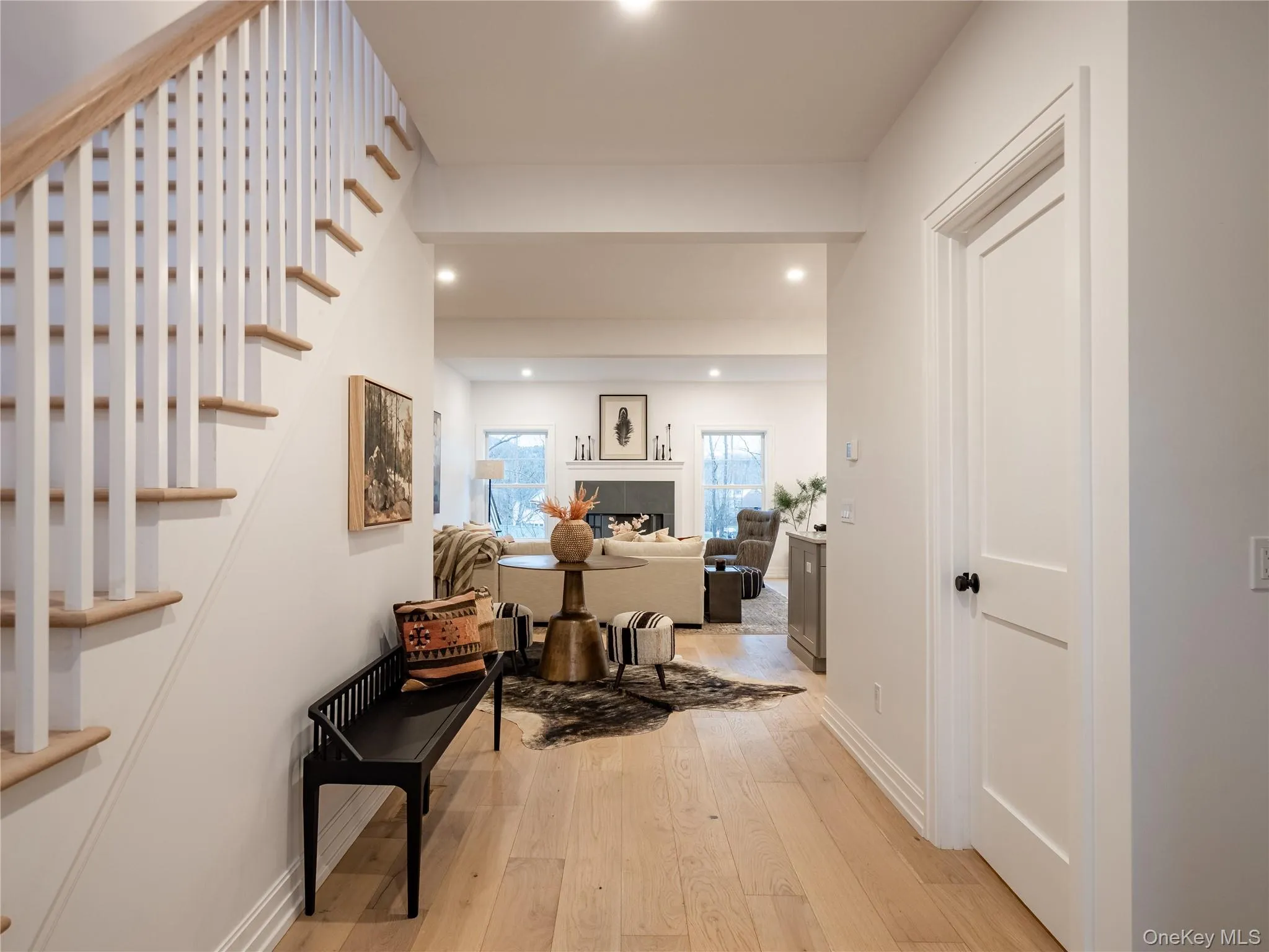 Hallway featuring light wood-style floors, stairway, and recessed lighting Hallway featuring light wood-style floors, stairway, and recessed lighting