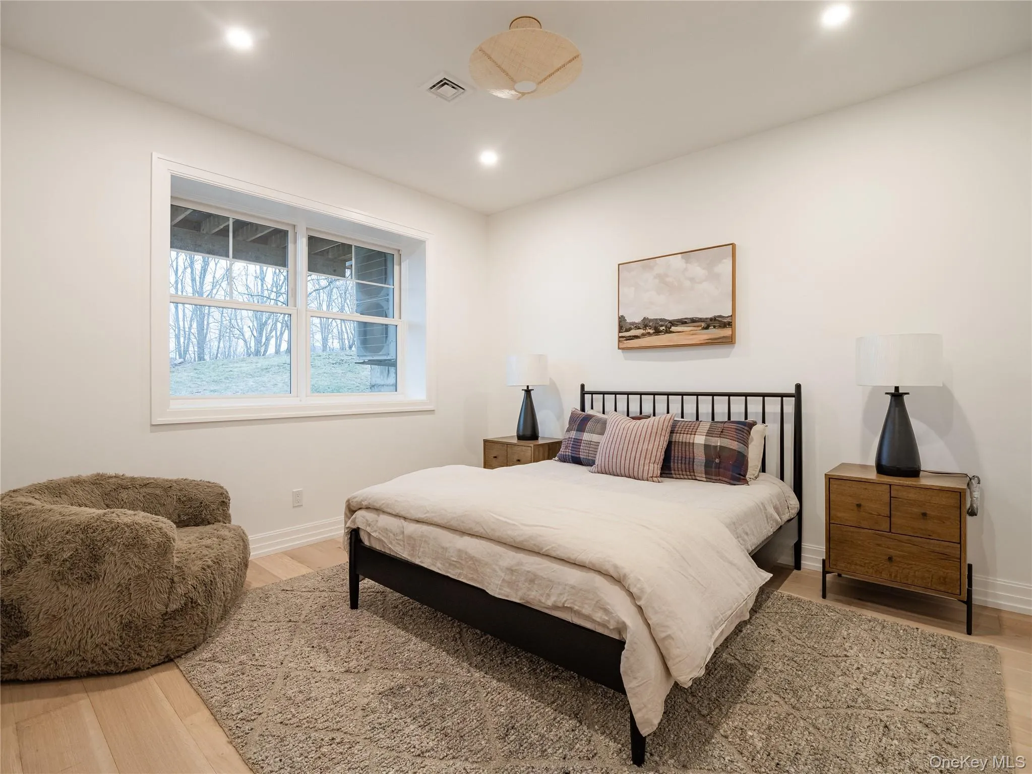Bedroom with light wood-style floors and recessed lighting Bedroom with light wood-style floors and recessed lighting