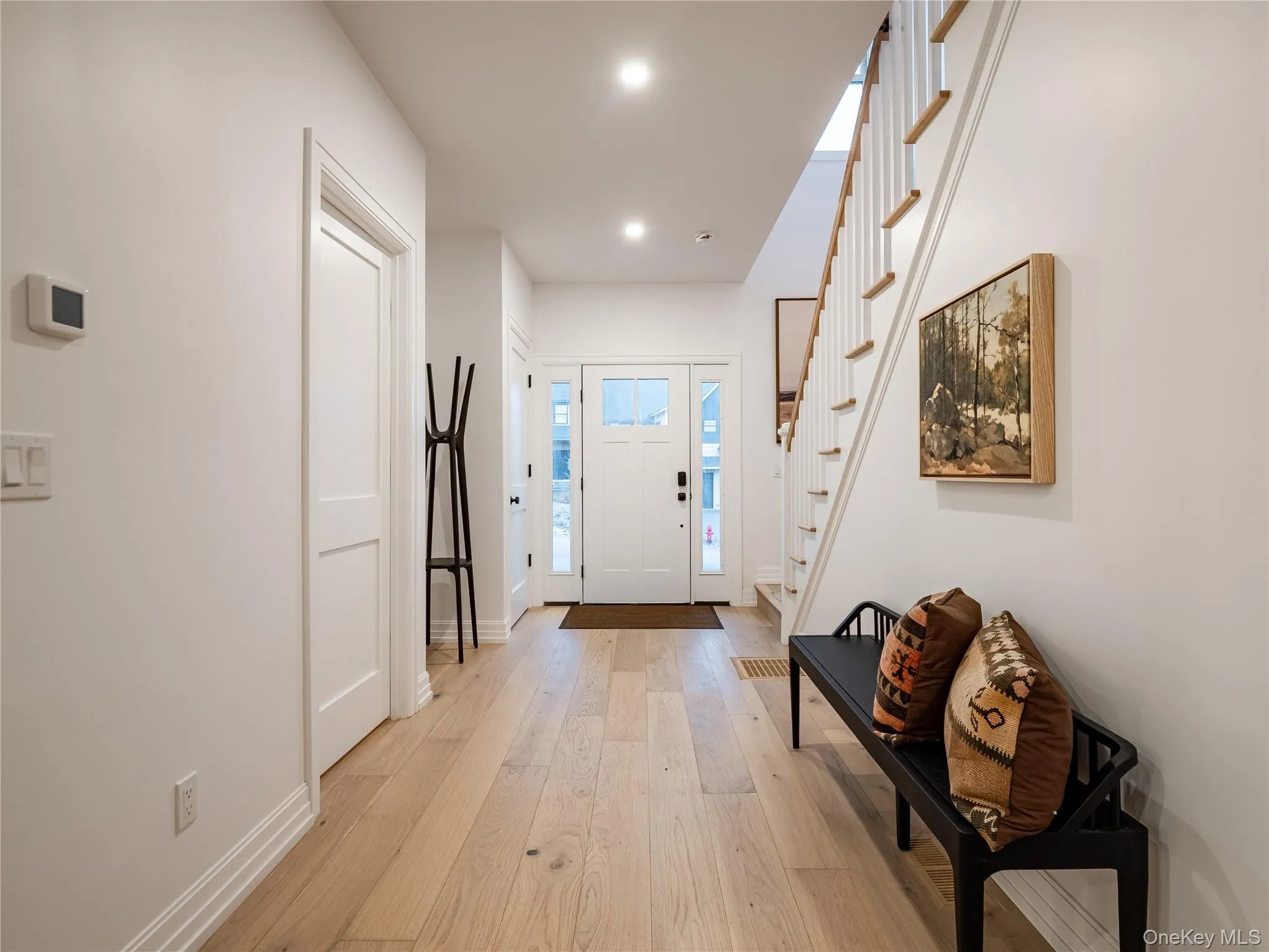 Entrance foyer with light wood-style floors and stairs Entrance foyer with light wood-style floors and stairs