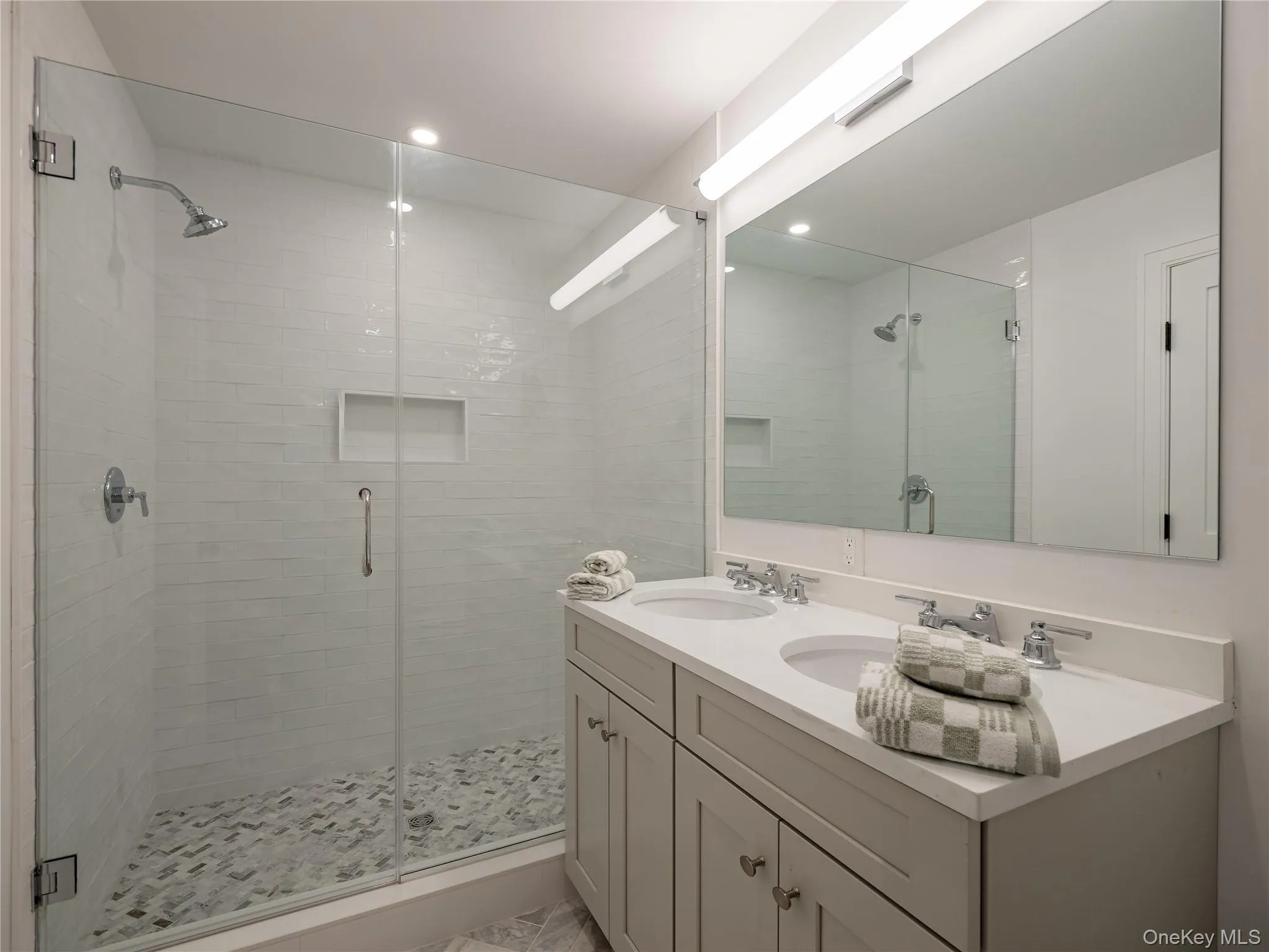 Full bathroom featuring double vanity and a shower stall Full bathroom featuring double vanity and a shower stall