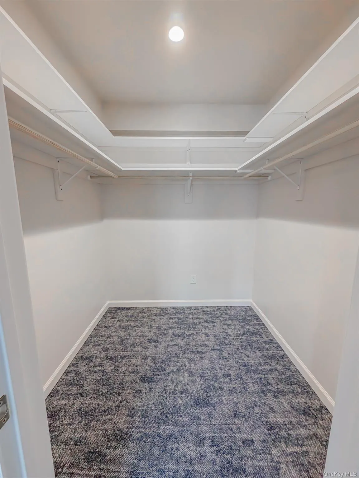 Walk in closet with dark colored carpet Walk in closet with dark colored carpet