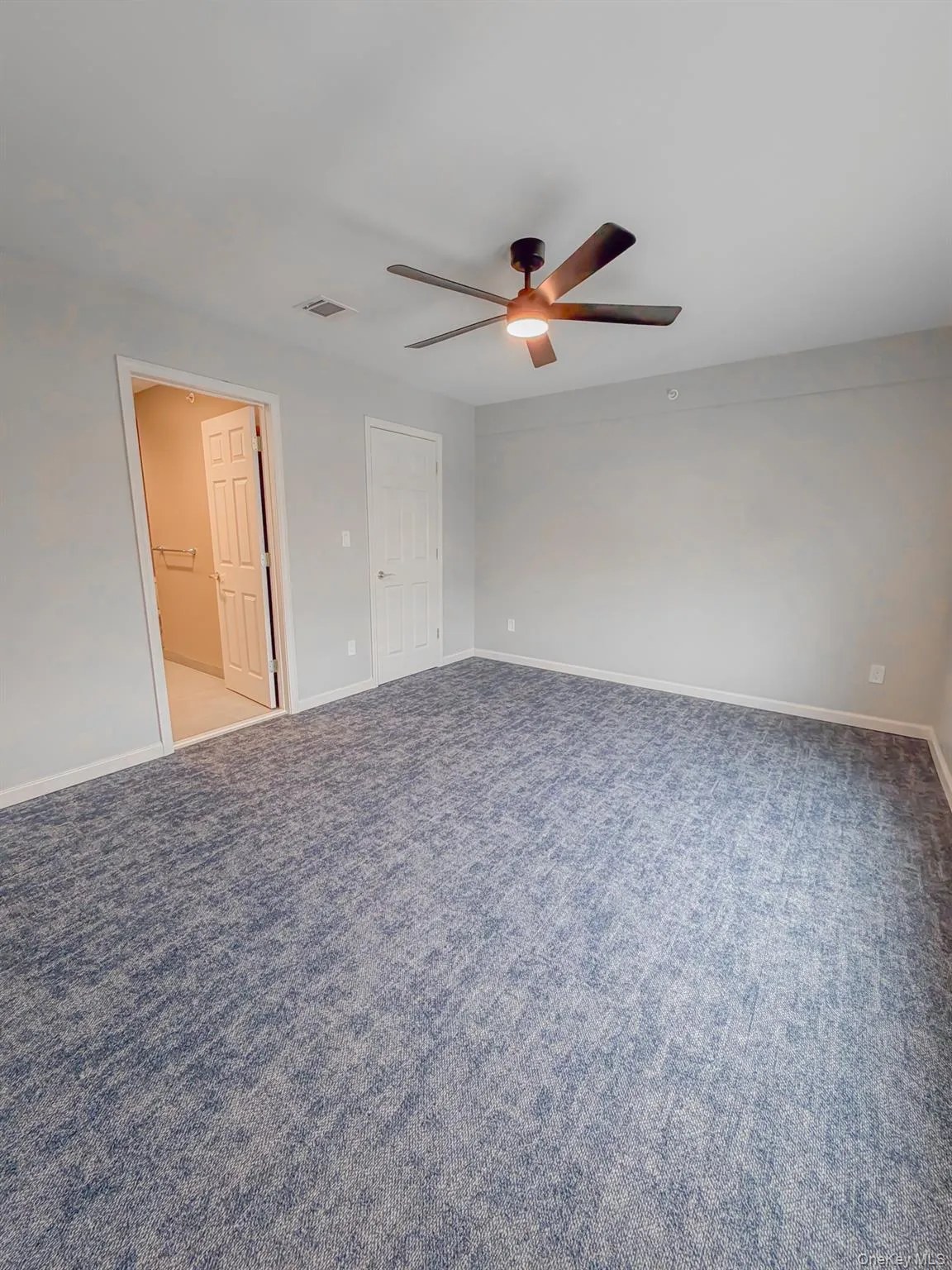 Unfurnished bedroom with ceiling fan and carpet floors Unfurnished bedroom with ceiling fan and carpet floors