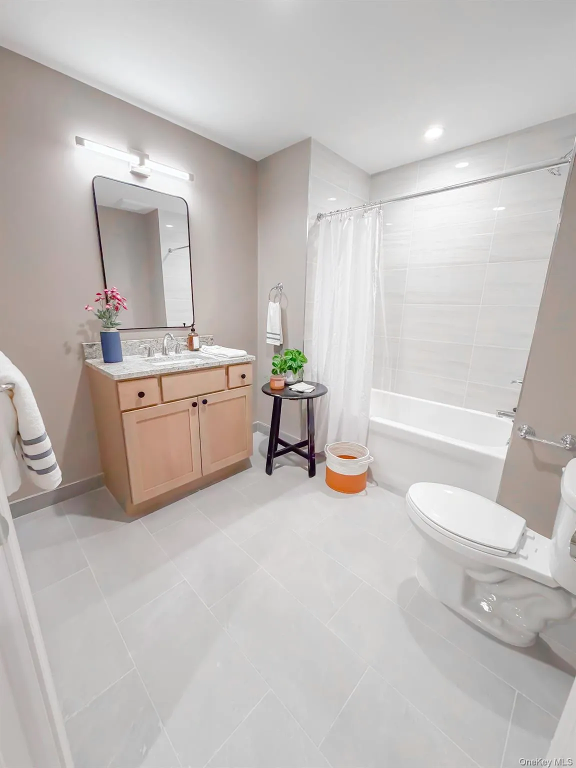 Bathroom featuring vanity, shower / tub combo with curtain, light tile patterned floors, and recessed lighting Bathroom featuring vanity, shower / tub combo with curtain, light tile patterned floors, and recessed lighting