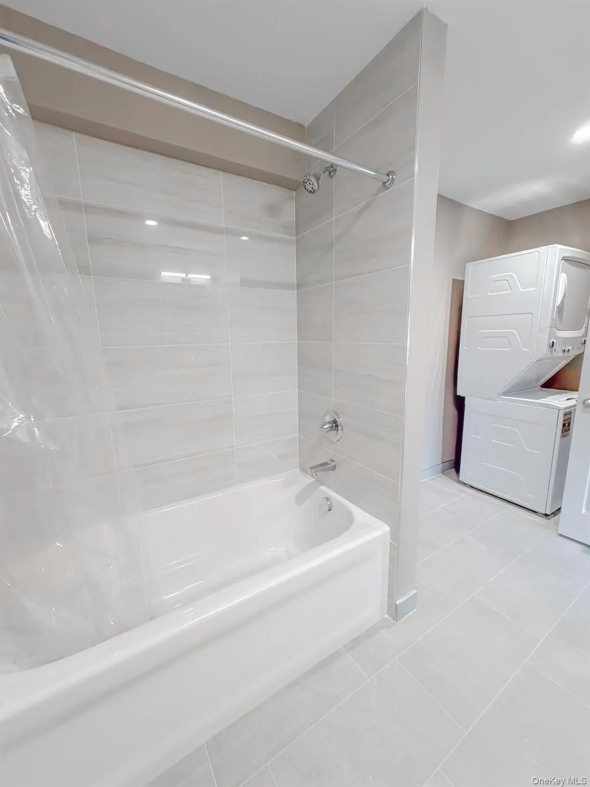 Full bath featuring light tile patterned floors and shower / bath combo Full bath featuring light tile patterned floors and shower / bath combo