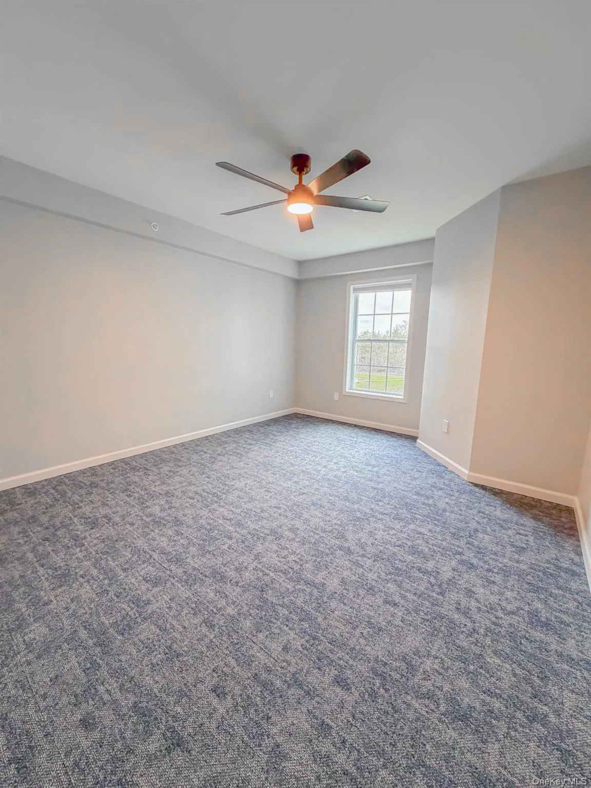Spare room with dark carpet and a ceiling fan Spare room with dark carpet and a ceiling fan