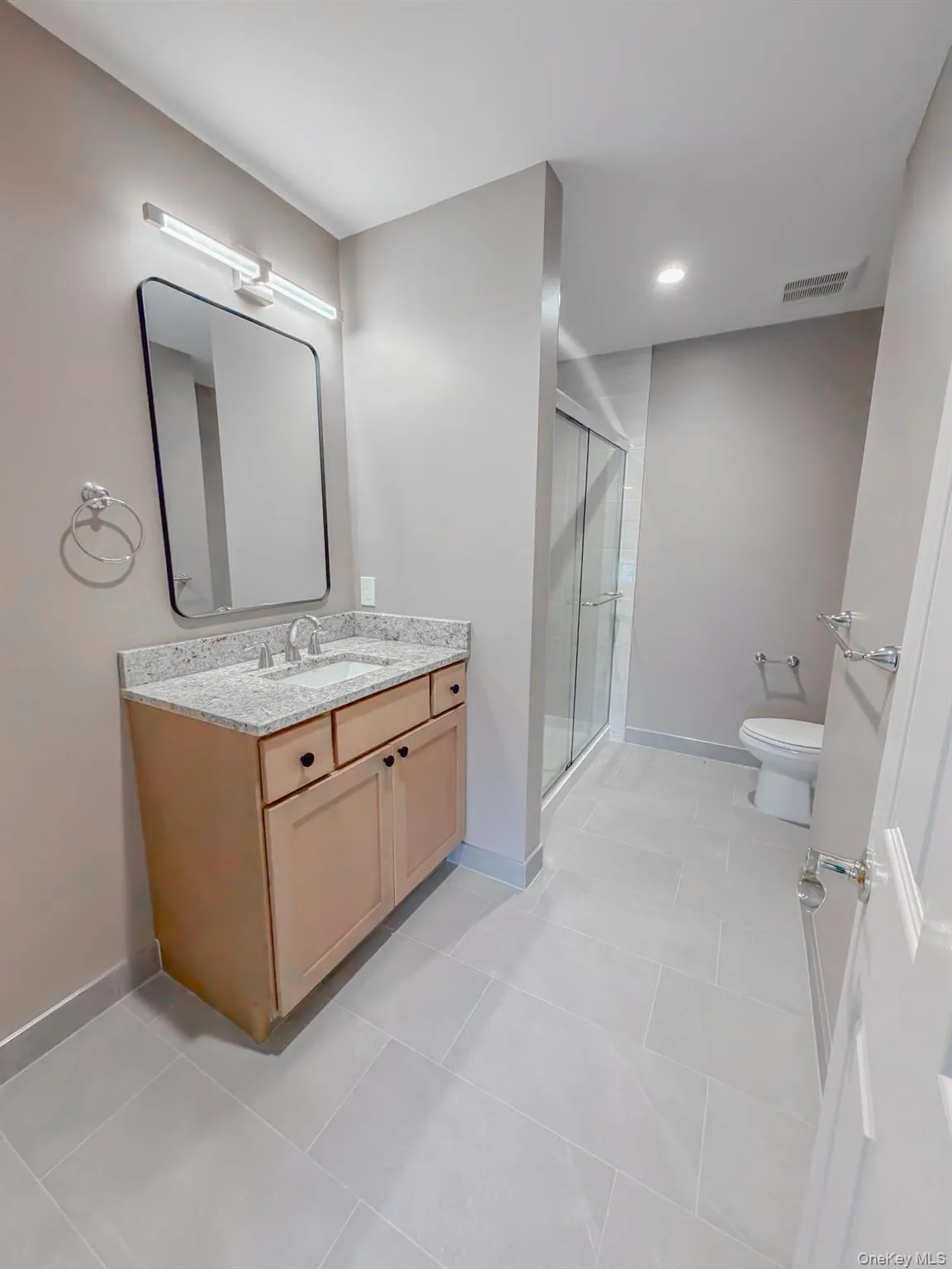 Bathroom featuring vanity, a shower stall, light tile patterned floors, and recessed lighting Bathroom featuring vanity, a shower stall, light tile patterned floors, and recessed lighting